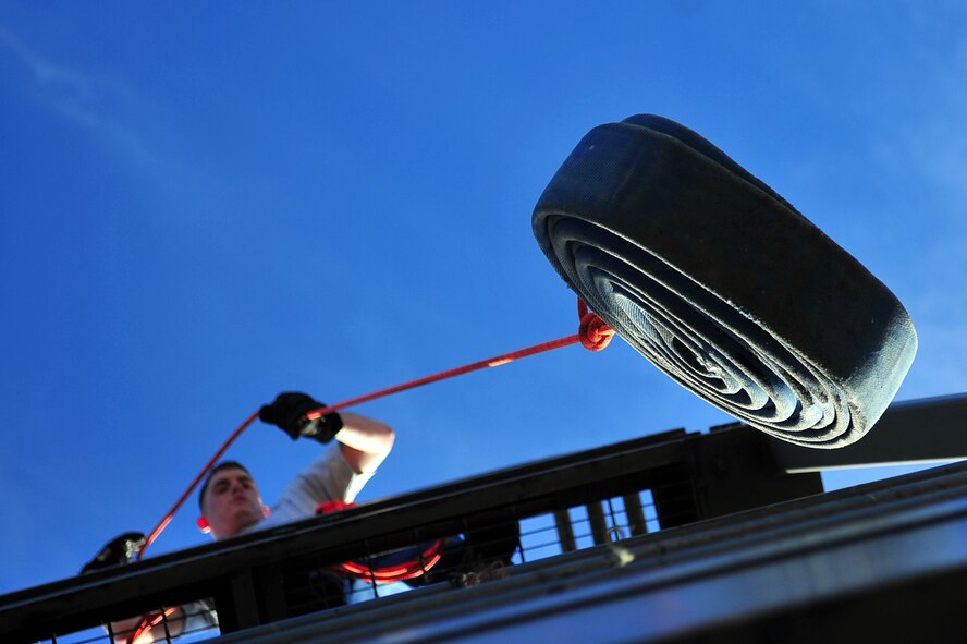 U.S. Air Force Airman 1st Class Donald Henderson, 4th Equipment Maintenance Squadron aircraft structural maintenance apprentice, hoists a fire hose while competing in the firefighter challenge at Seymour Johnson Air Force Base, N.C., Nov. 22, 2013.  The challenge was one of many athletic events hosted during a quarterly Comprehensive Airman Fitness Day, which promotes the physical, spiritual, mental and social aspects of Airmen’s lives. (U.S. Air Force photo by Tech. Sgt. Brittany E. Jones)