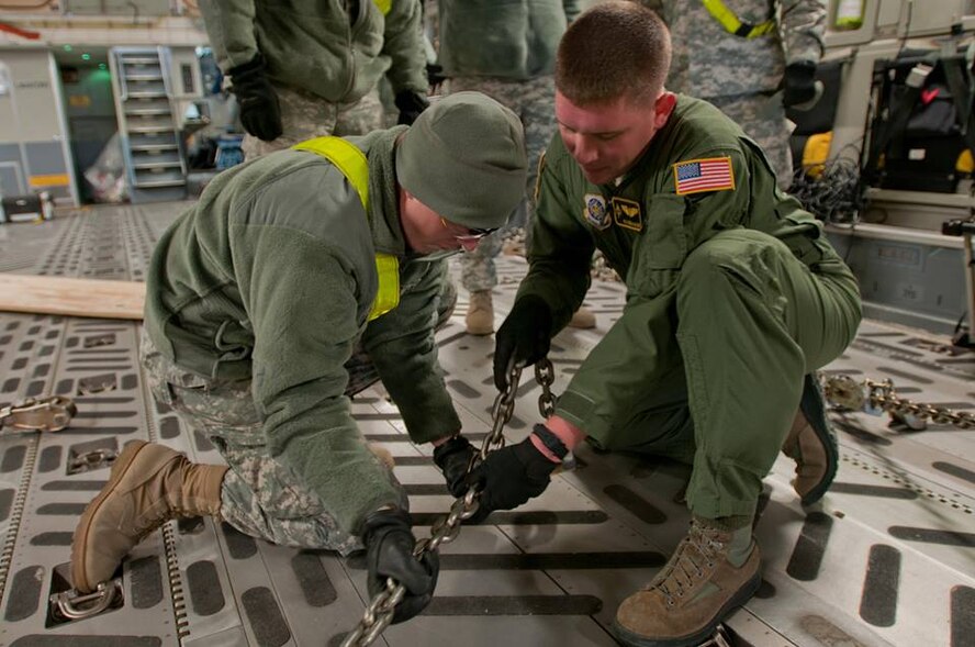 Airmen from Travis' 21st Airlift Squadron participated in a joint training with Soldiers from the 1st Brigade, 1st Infantry Division, and 1st Combat Aviation Brigade, 1st Infantry Division, at Manhattan Regional Airport in Manhattan, Kan., Nov. 13. Working together, Soldiers and Airmen loaded a C-17 Globemaster III to fine-tune loading procedures used for rapid deployments. (U.S. Army photo/Sgt. Michael Leverton)