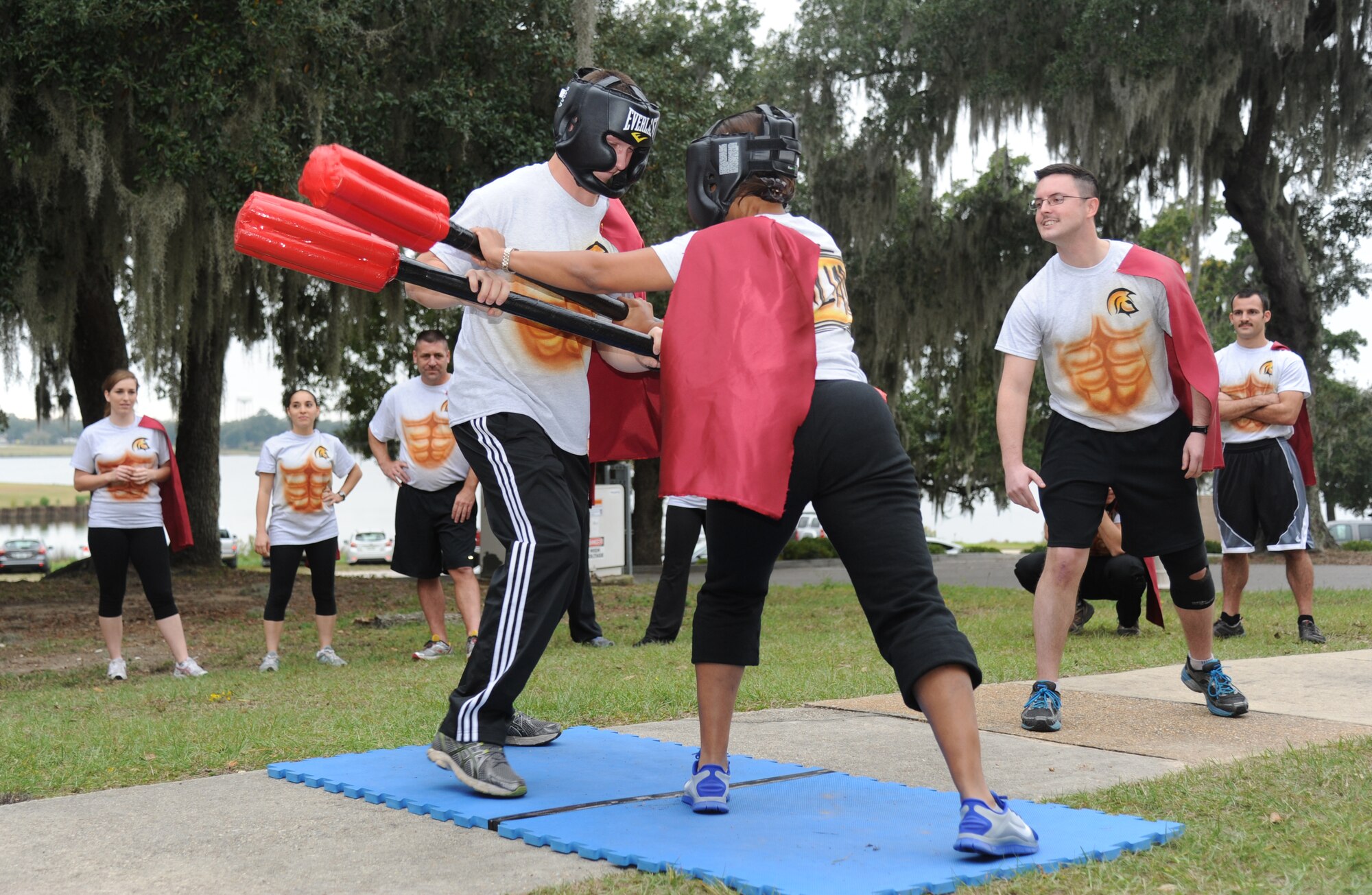 Second Lts. Adam Byne and Adelia McClain, 333rd Training Squadron Undergraduate Cyberspace Officer Training course students, participate in the gladiator duel as 2nd Lt. Jonathan LaPlante, 333rd TRS UCT student, judges the match during “Drop Night” Nov. 21, 2013, at the marina, Keesler Air Force Base, Miss. The Spartan themed event also included the UCT students receiving their first assignments.  (U.S. Air Force photo by Kemberly Groue)