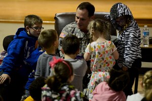 U.S. Army Lt. Gen. Keith C. Walker, Army Capabilities Integration Center deputy commanding general, reads “Odd Velvet” to children during a “Tell Me a Story” event at General Stanford Elementary at Fort Eustis, Va., Nov. 21, 2013. The TMAS program began in 2005 as a way to empower military children by using literature and stories they can relate to. (U.S. Air Force photo by Staff Sgt. Ciara Wymbs/Released)
