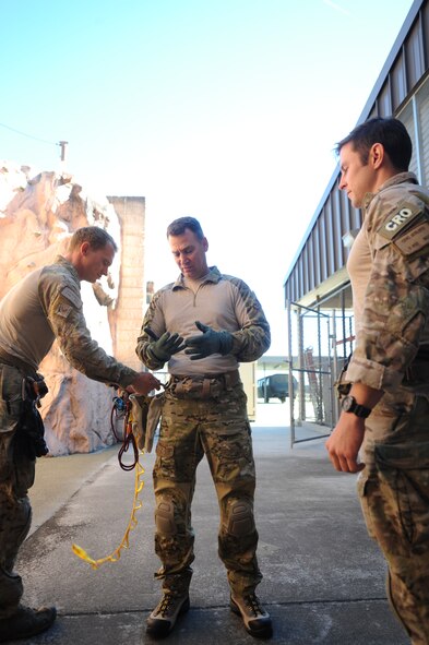 U.S. Air Force Staff Sgt. William Blakeney, left, 38th Rescue Squadron pararescueman, checks the gear of Col. Chad Franks, 23d Wing commander, center, as 1st Lt. Carl Schleich, 38th RQS combat rescue officer, looks on at Moody Air Force Base, Ga., Nov. 19, 2013. Franks participated in alternate insertion/extraction training with the 38th RQS to experience what pararescuemen do. (U.S. Air Force photo by Airman 1st Class Sandra Marrero/Released)
