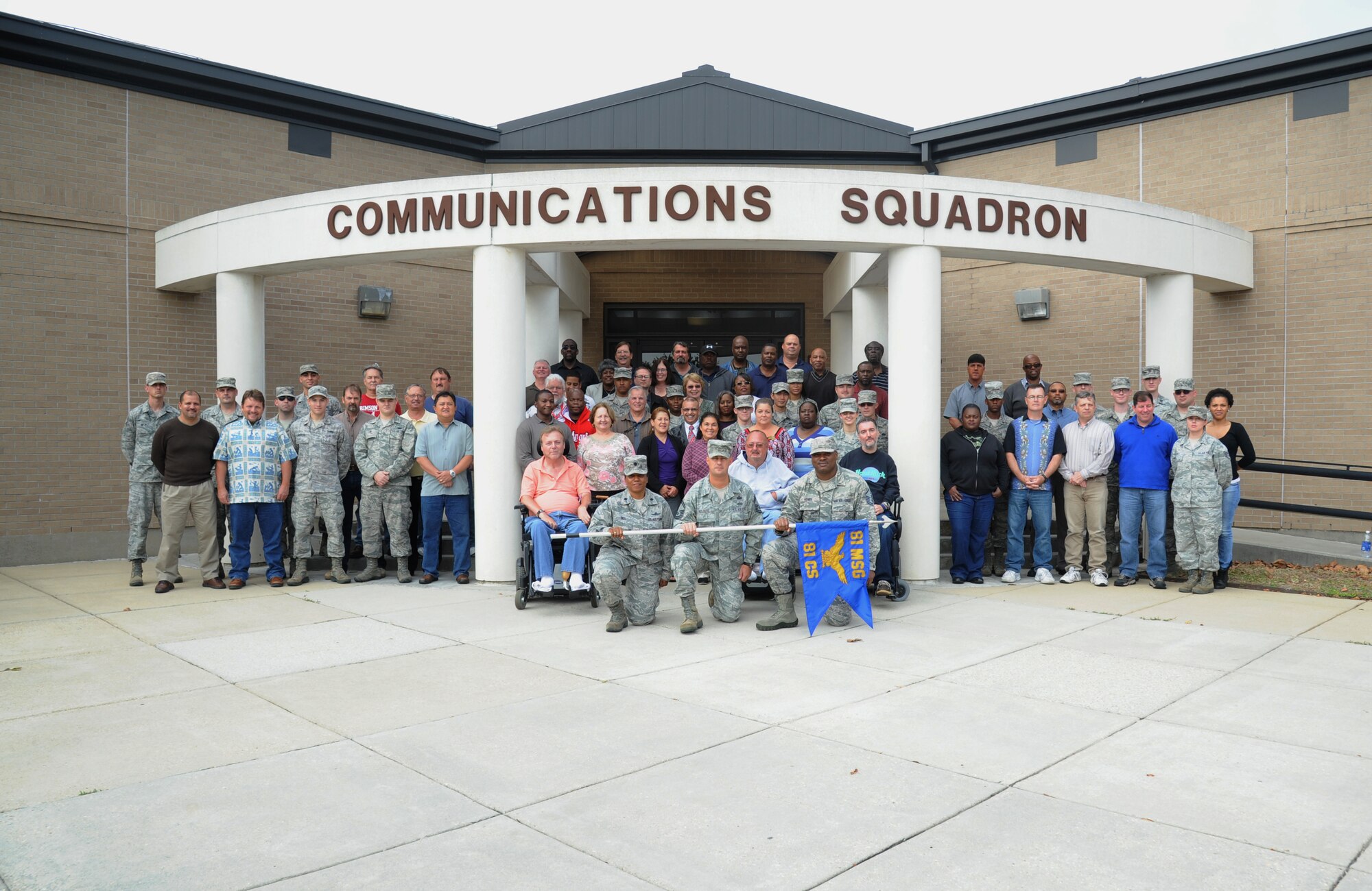 Members of the 81st Communications Squadron pose for a group photo in front of their building Nov. 21, 2013, at Keesler Air Force Base, Miss.  The 81st CS was recently awarded the 2013 Air Education and Training Command Information Dominance, Lt. Gen. Harold W. Grant Unit Award.  (U.S. Air Force photo by Kemberly Groue)