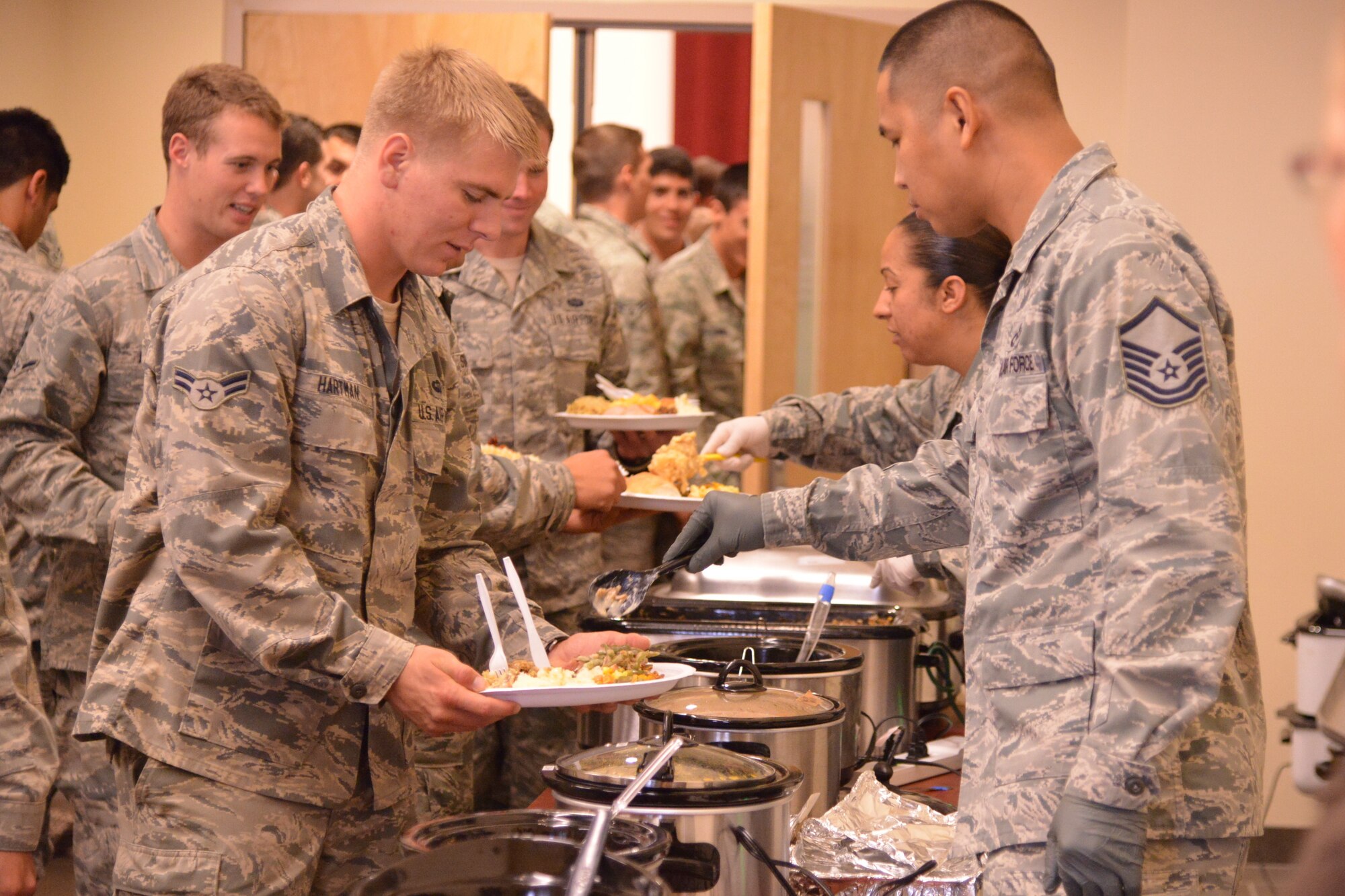 Pararescue trainees from the 342nd Training Squadron, Detachment 1, enjoy a Thanksgiving meal. The event, which has become an annual tradition, was organized by members of the AFRL Contracting Division with the help of donations from the local community.  (Photo by Ken Moore)