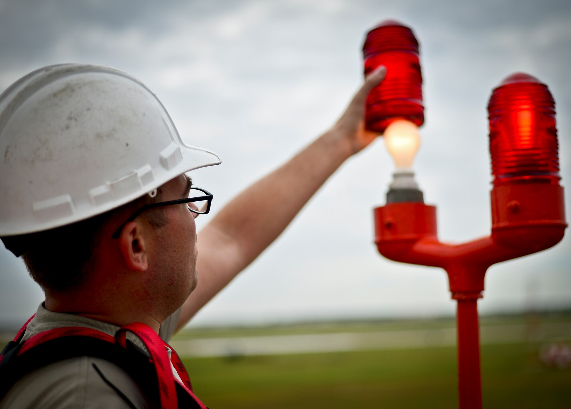 Senior Airman Brent Harmor 6th Communications Squadron airfield systems technician, inspects the lighting system attached to a tactical air navigation tower at MacDill Air Force Base, Fla., Nov. 5, 2013. Harmor conducted numerous routine inspections of the TACAN station to ensure proper functionality and reliability. (U.S. Air Force photo by Staff Sgt. Brandon Shapiro/Released)