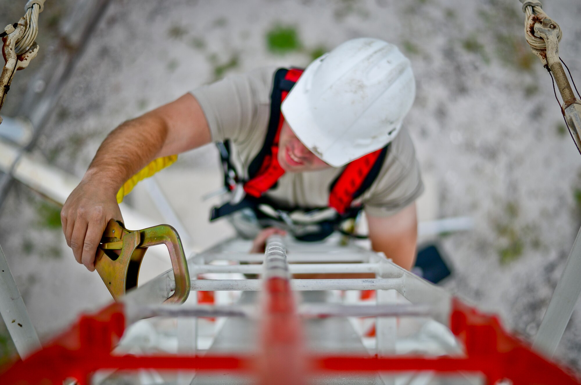 Senior Airman Brent Harmor 6th Communications Squadron airfield systems technician, scales a tactical air navigation ladder at MacDill Air Force Base, Fla., Nov. 5, 2013. Harmor climbed the tower in order to make repairs the lighting system and the structure containing the electrical equipment. (U.S. Air Force photo by Staff Sgt. Brandon Shapiro/Released)