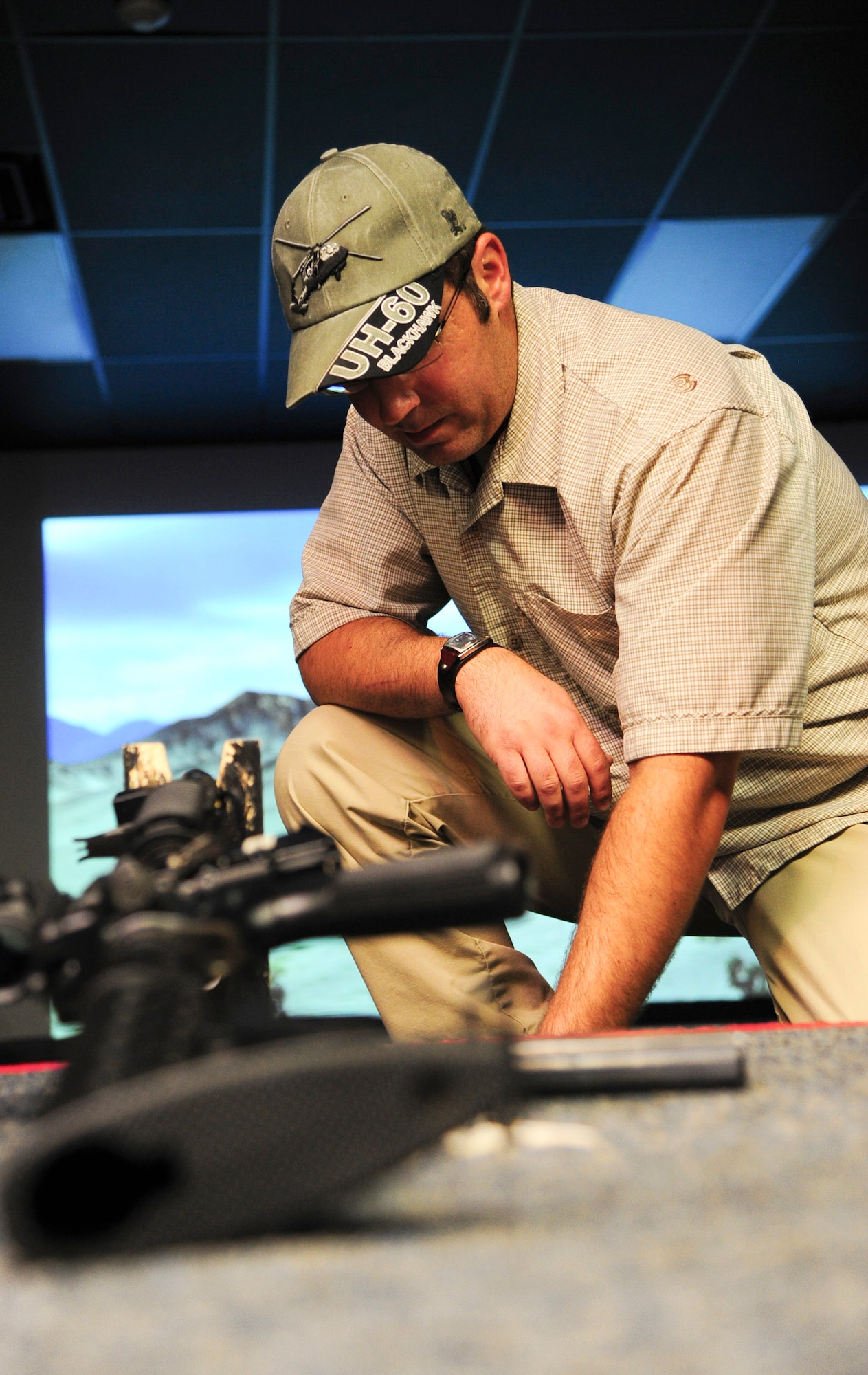 ALTUS AIR FORCE BASE, Okla. -- Nathan Dunnigan, 97th Security Forces Squadron expeditionary skills combat arms instructor, prepares a weapon for simulated shooting with the Engagement Skills Trainer 2000 training simulator Nov. 21, 2013. The weapons used with the EST 2000 are designed to look, shoot and feel like a real weapon, enhancing familiarization prior to shooting at a live weapons range. Weapons supported by the EST 2000 at Altus AFB include the M4 carbine, M16A2 rifle, M9 pistol, M249, M240 machine gun and the M203 grenade launcher. (U.S. Air Force Photo by Senior Airman Lausanne Genuino/Released)