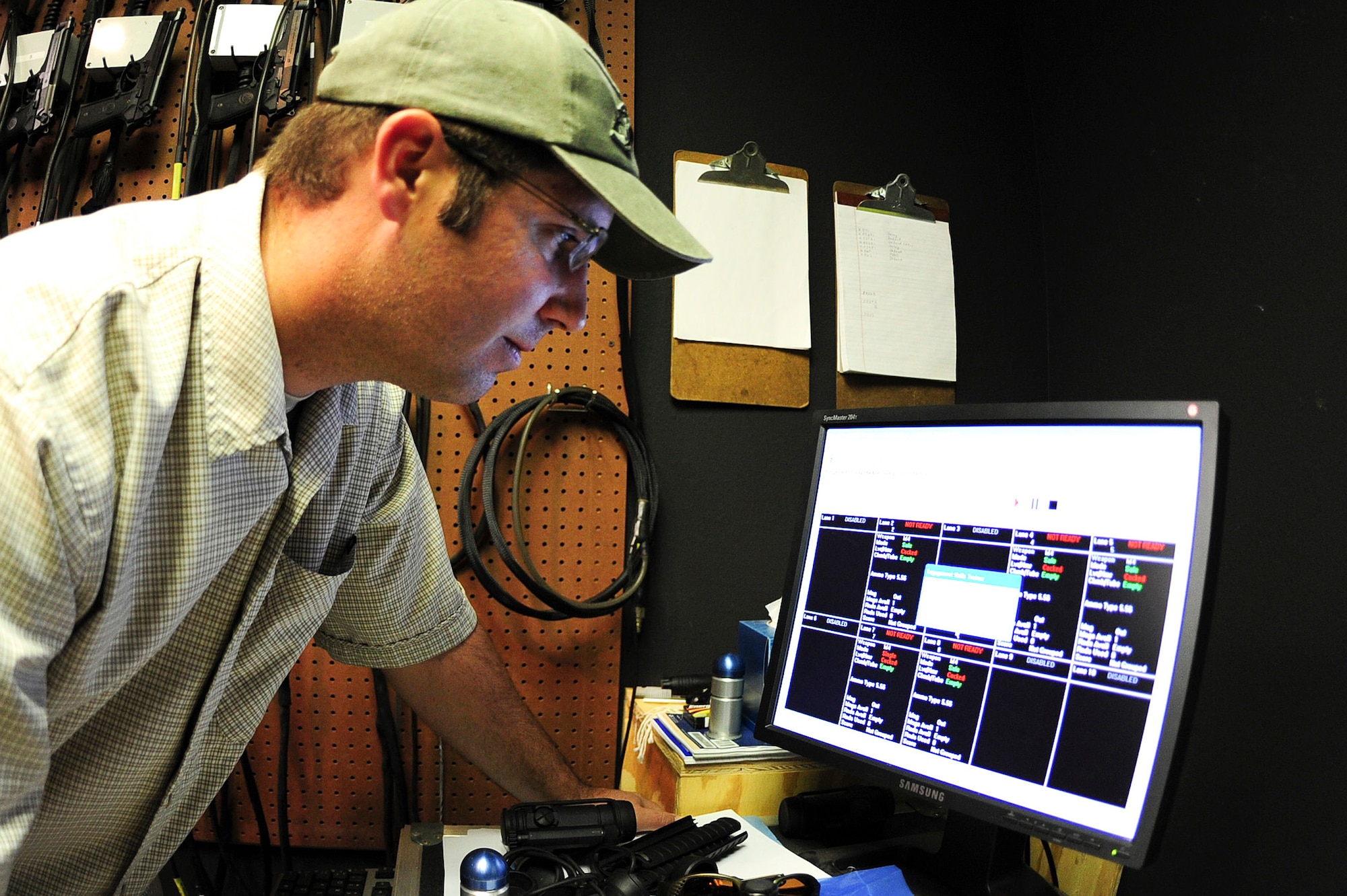 ALTUS AIR FORCE BASE, Okla. -- Nathan Dunnigan, 97th Security Forces Squadron expeditionary skills combat arms instructor, ensures all lanes are ready to begin firing with the Engagement Skills Training 2000 training simulator Nov. 21, 2013. The EST 2000 is a system that provides realistic marksmanship and combat scenario training, increasing familiarization and proficiency prior to live firing at a weapons range. (U.S. Air Force Photo by Senior Airman Lausanne Genuino/Released)