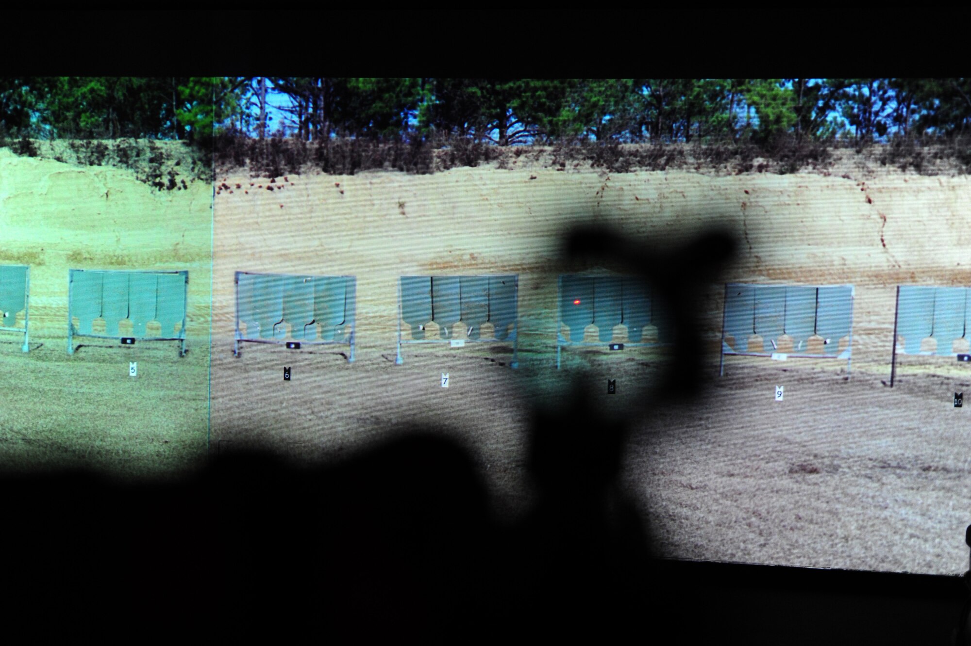 ALTUS AIR FORCE BASE, Okla. -- A weapon is aimed at a simulated range using the Engagement Skills Training 2000 training simulator Nov. 13, 2013. The EST 2000 is a system that provides realistic marksmanship and combat scenario training, increasing familiarization and proficiency prior to live firing. Weapons supported by the EST 2000 at Altus AFB include the M4 carbine, M16A2 rifle, M9 pistol, M249, M240 machine gun and the M203 grenade launcher. (U.S. Air Force Photo by Senior Airman Lausanne Genuino/Released)