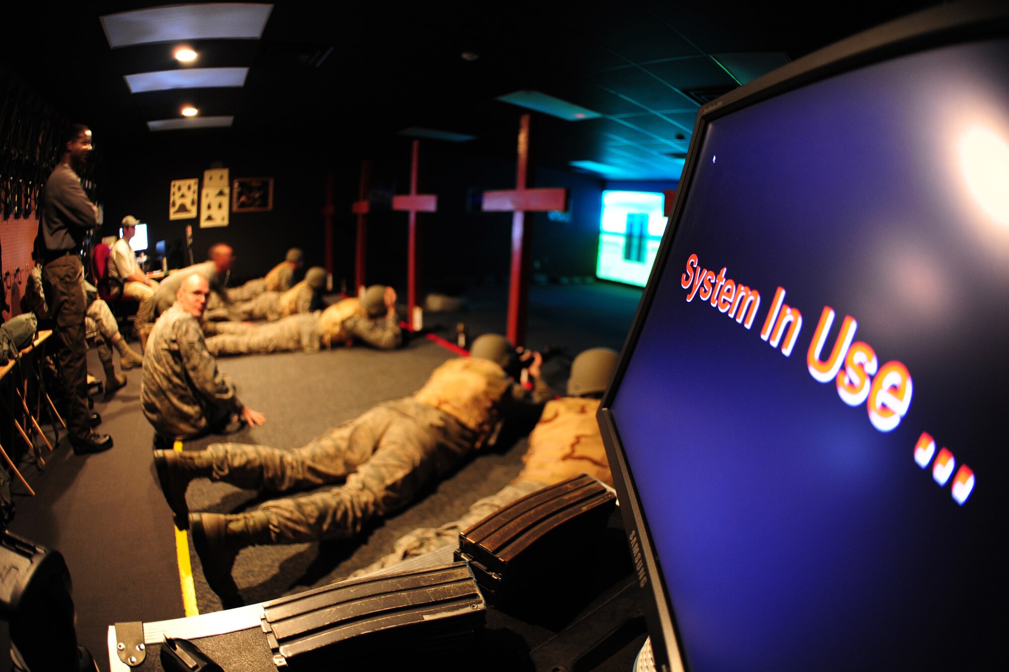 ALTUS AIR FORCE BASE, Okla. -- Expeditionary skills students shoot in the prone position during a combat arms class using the Engagement Skills Trainer 2000 training simulator Nov. 21, 2013. The weapons used with the EST are designed to look, shoot and feel like real weapons, enhancing familiarization prior to shooting at a live range. Weapons supported by the EST 2000 at Altus AFB include the M4 carbine, M16A2 rifle, M9 pistol, M249, M240 machine gun and the M203 grenade launcher. (U.S. Air Force Photo by Senior Airman Lausanne Genuino/Released)