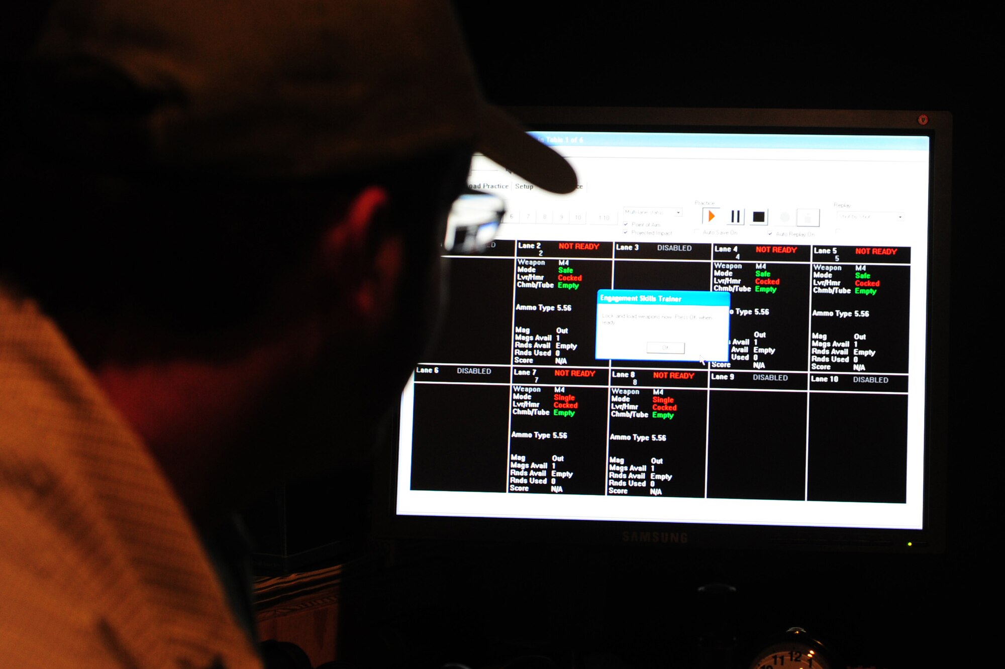 ALTUS AIR FORCE BASE, Okla. -- Nathan Dunnigan, 97th Security Forces Squadron expeditionary skills combat arms instructor, ensures all lanes are ready to begin firing with the Engagement Skills Training 2000 training simulator Nov. 21, 2013. The EST 2000 is a system that provides realistic marksmanship and combat scenario training, increasing familiarization and proficiency prior to live firing at a weapons range. (U.S. Air Force Photo by Senior Airman Lausanne Genuino/Released)