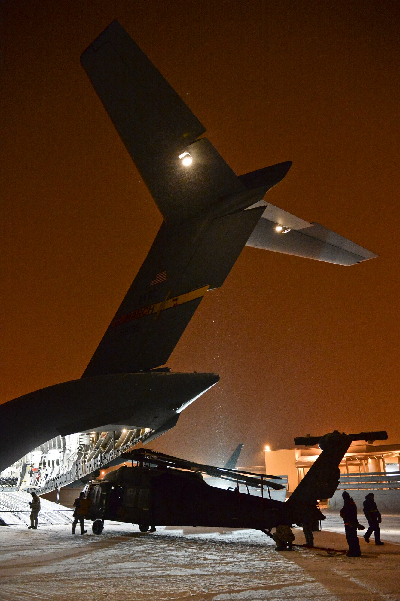 U.S. Army Soldiers from Fort Wainwright, Alaska, unload a UH-60 Black Hawk helicopter and equipment from a U.S. Air Force C-17 Globemaster III assigned to the 452nd Air Mobility Wing, March Air Reserve Base, Calif., Nov. 18, 2013, Eielson Air Force Base, Alaska. Fort Wainwright Soldiers utilized Eielson's runways to return its assets from deployed locations. (U.S. Air Force photo by Airman 1st Class Peter Reft/Released)