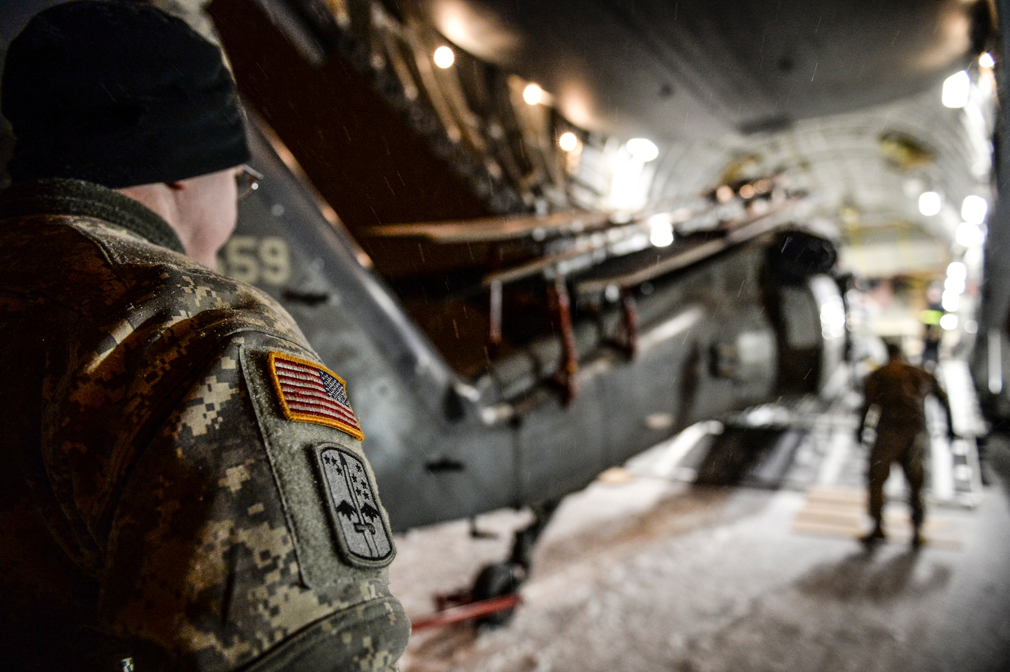 A U.S. Army Soldier from Fort Wainwright, Alaska, supervises the unloading of a UH-60 Black Hawk helicopter from a U.S. Air Force C-17 Globemaster III assigned to the 452nd Air Mobility Wing, March Air Reserve Base, Calif., Nov. 18, 2013, Eielson Air Force Base, Alaska. Eielson Air Force Base plays an important role in enabling Fort Wainwright to deploy and transport assets in and out of Interior Alaska. (U.S. Air Force photo by Airman 1st Class Peter Reft/Released)