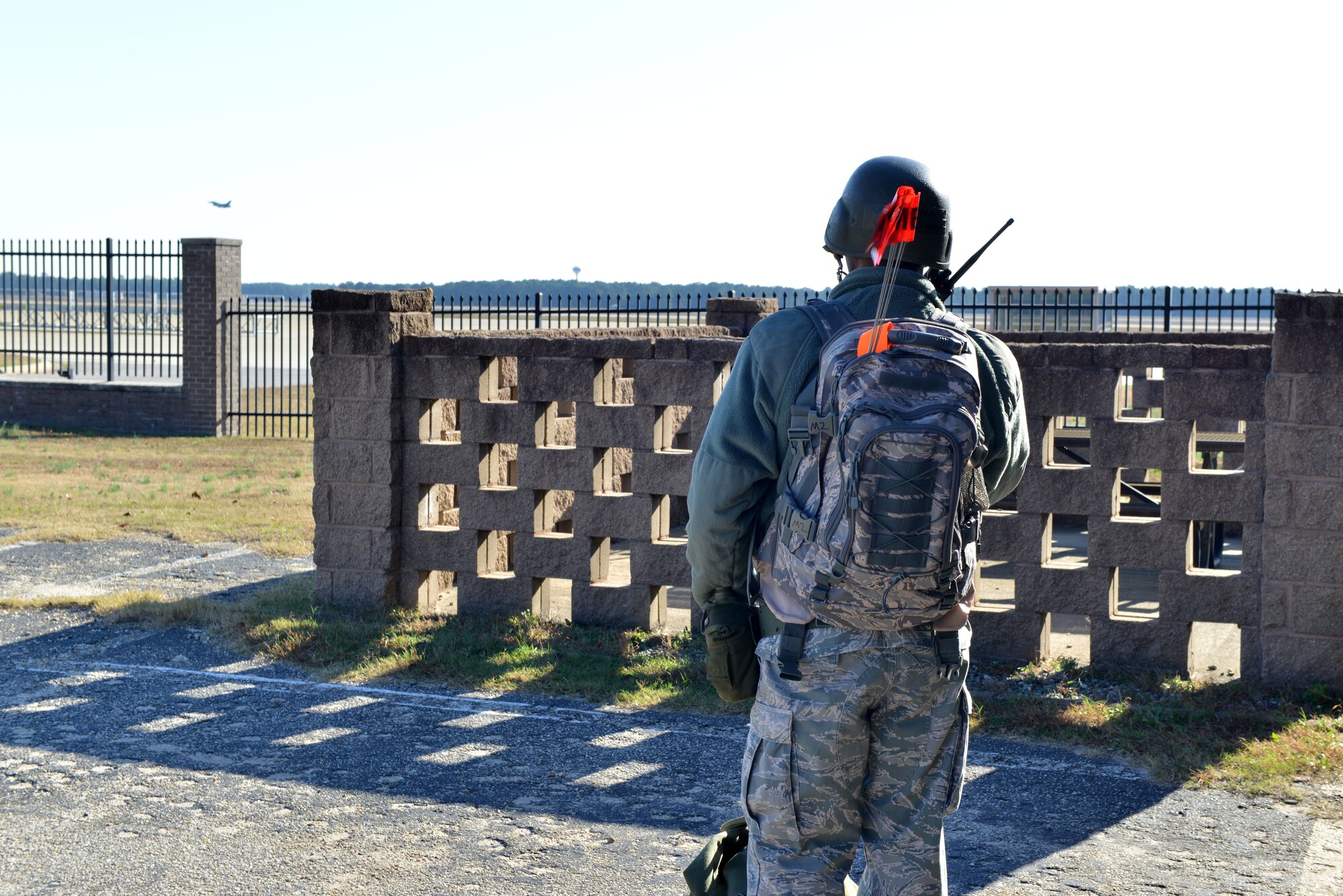 U.S. Air Force Staff Sgt. Willie Hogan, 20th Comptroller Squadron budget analyst, uses a radio while watching an F-16 Fighting Falcon take off at Shaw Air Force Base, S.C., Nov. 20, 2013. Hogan was part of a post-attack reconnaissance team during a recent operational readiness exercise which tested the 20th Fighter Wing’s ability to maintain mission capability. (U.S. Air Force photo by Airman 1st Class Jensen L. Stidham)