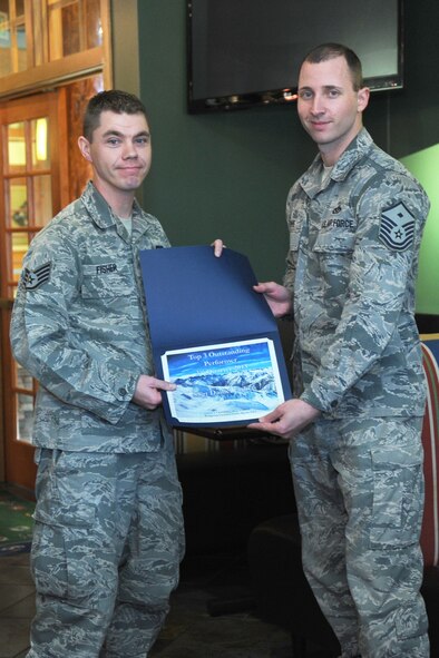Staff Sgt. Daniel Fisher, 341st Security Forces Group Tactical Response Force assistant NCO in charge, receives a certificate for being the 3rd Quarter Top 3 Outstanding Performer from Master Sgt. Bradley Thye, 341st Medical Group first sergeant, at the Grizzly Bend on Nov. 19. Fisher received the award after being nominated by Master Sgt. Todd Vidic, 341st SFG TRF NCO in charge, for having a crucial role in revamping the 341st SFG TRF armory. (U.S. Air Force photo/Senior Airman Katrina Heikkinen) 