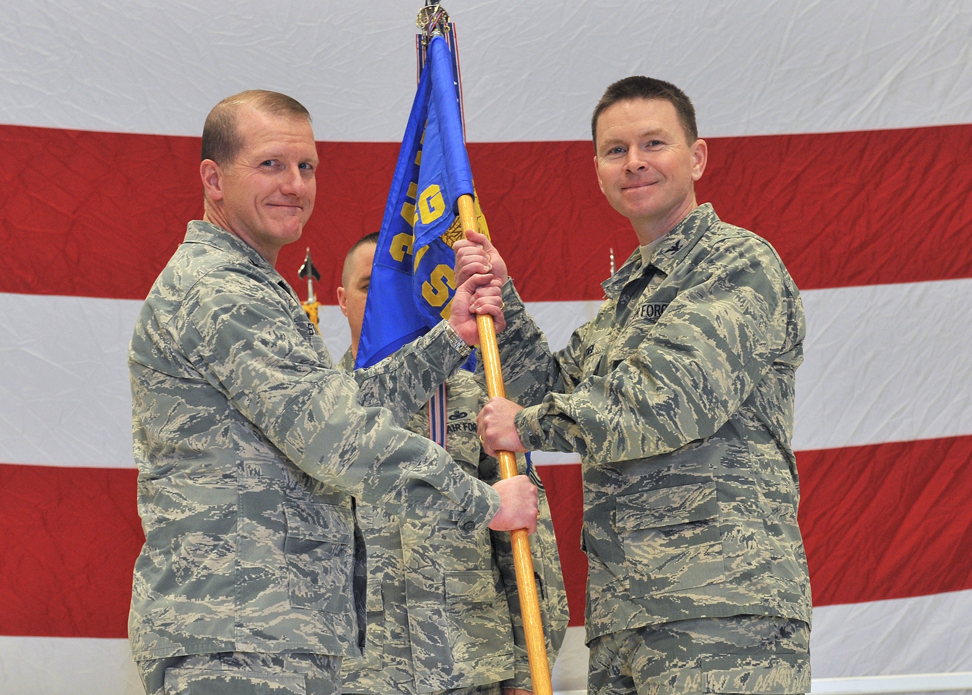 Col. Kenneth O’Neil (right) accepts command of the 341st Security Forces Group from Col. Robert Stanley, 341st Missile Wing commander, Nov. 18 at the 3-Bay Hangar.  Chief Master Sgt. Keith Collins, 741st Missile Security Forces Squadron security forces manager (background), looks on.  (U.S. Air Force photo/ John Turner)