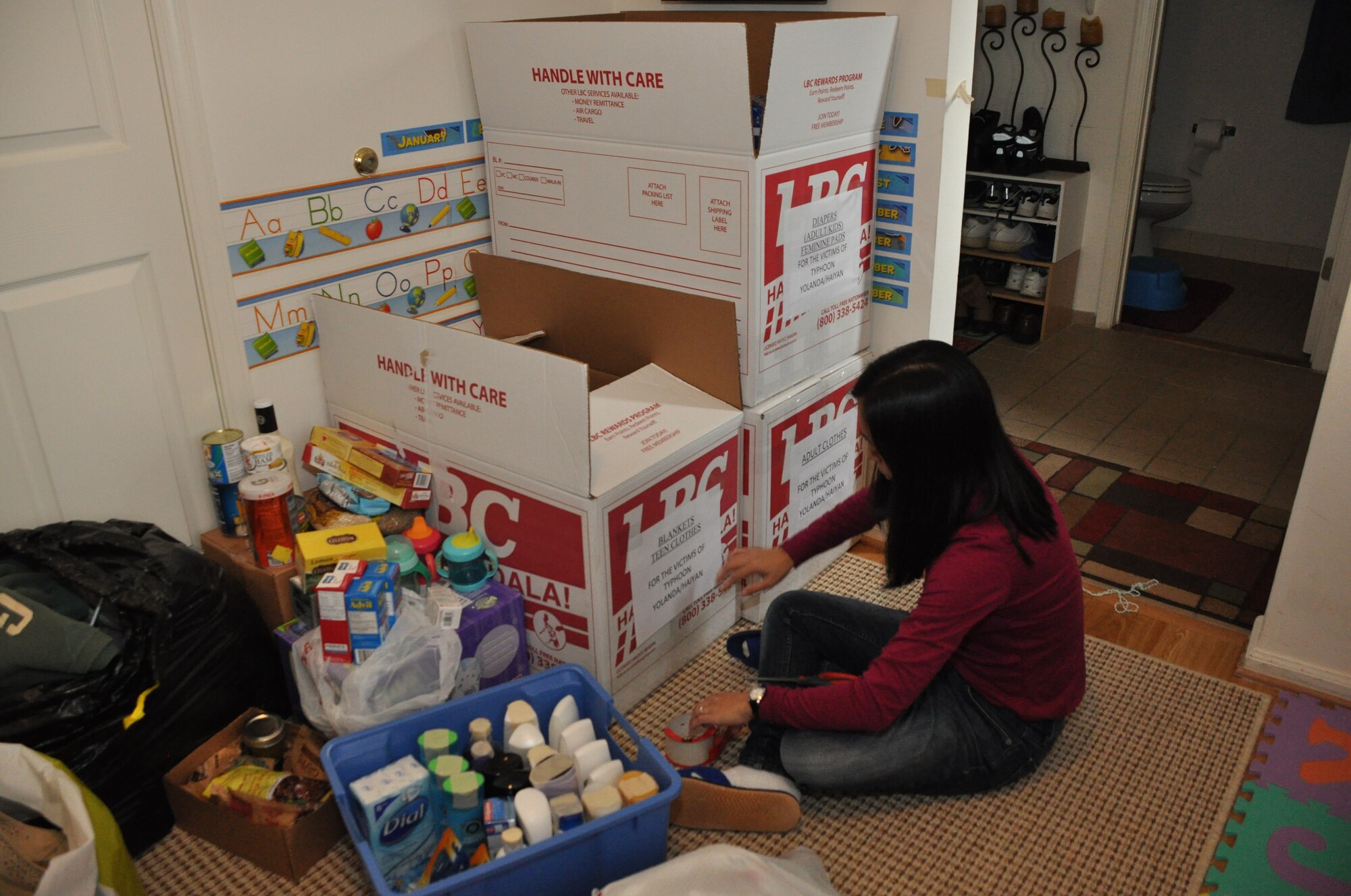 459th Air Refueling Wing spouse, Marieta Manio-Brown, labels donations boxes to be shipped to the Philippines in the wake of Typhoon Haiyan, Joint Base Andrews, Md., November 21, 2013. Haiyan hit the eastern seaboard of the Philippines on Nov. 8 and the death toll is said to reach close to 5,000 people. (U.S. Air Force photo/ Staff Sgt. Katie Spencer)