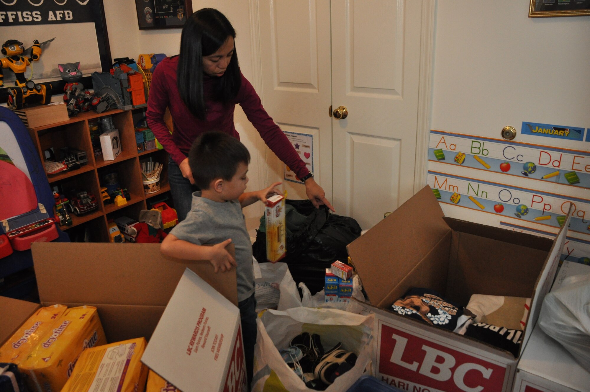 459th Air Refueling Wing spouse, Marieta Manio-Brown, and her son James, oraganize donations to be shipped to the Philippines in the wake of Typhoon Haiyan, Joint Base Andrews, Md., November 21, 2013. Haiyan hit the eastern seaboard of the Philippines on Nov. 8 and the death toll is said to reach close to 5,000 people. (U.S. Air Force photo/ Staff Sgt. Katie Spencer)