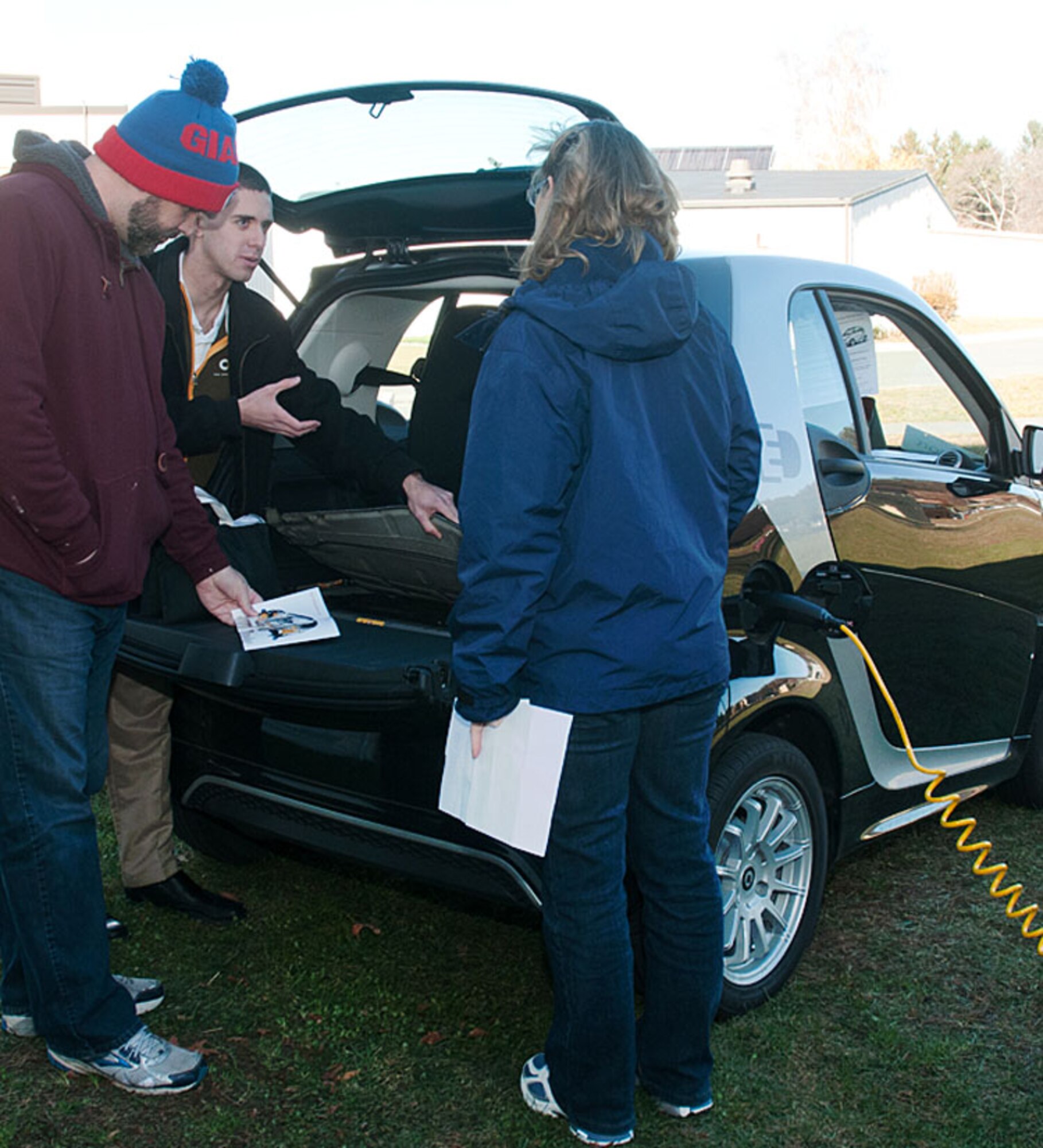 HANSCOM AIR FORCE BASE, Mass. -- Dan Fava, a Smart Car dealer, discusses with Paul Shoesmith and Barbara Cook about features in an electric Smart Car at the Home Energy Expo Nov. 20 outside the Fitness and Sports Center. Vendors were on hand to promote services and products related to energy efficiency. (U.S. Air Force photo by Mark Herlihy)