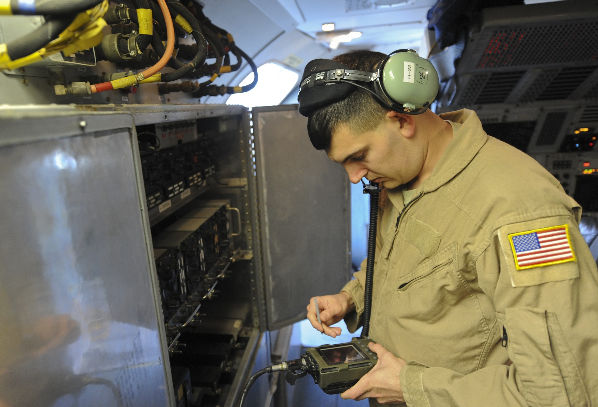 U.S. Air Force Airman 1st Class Daniel Deas, 968th Expeditionary Airborne Air Control Squadron radio operator, inputs information in the on-board communications system at an undisclosed location in Southwest Asia Nov. 16, 2013. Deas is responsible for helping a large crew aboard an E-3 Sentry connect to multiple organizations on the ground or in the air. (U.S. Air Force photo by Staff Sgt. Jacob Morgan)