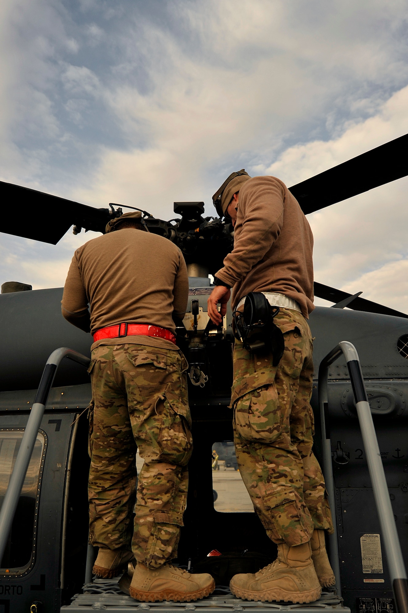 U.S. Air Force Airmen assigned to the 83rd Expeditionary Rescue Squadron perform routine maintenance on a HH-60G Pave Hawk at Bagram Airfield, Afghanistan Nov. 22, 2013. Every three days, preflight maintenance is done on the Pave Hawk to ensure that it remains safe and airworthy. (U.S. Air Force photo by Senior Airman Kayla Newman/Released)