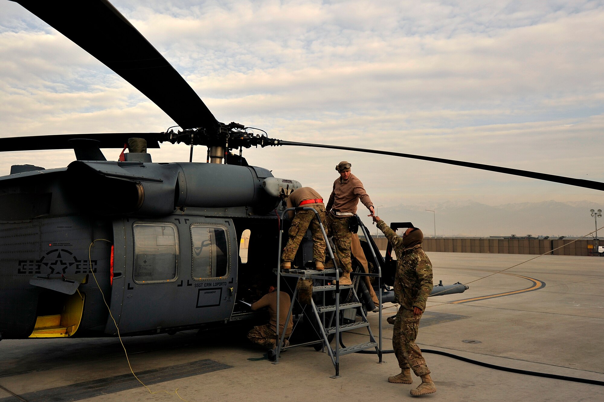 U.S. Air Force Airmen assigned to the 83rd Expeditionary Rescue Squadron perform routine maintenance on a HH-60G Pave Hawk at Bagram Airfield, Afghanistan Nov. 22, 2013. Every three days, preflight maintenance is done on the Pave Hawk to ensure that it remains safe and airworthy. (U.S. Air Force photo by Senior Airman Kayla Newman/Released)