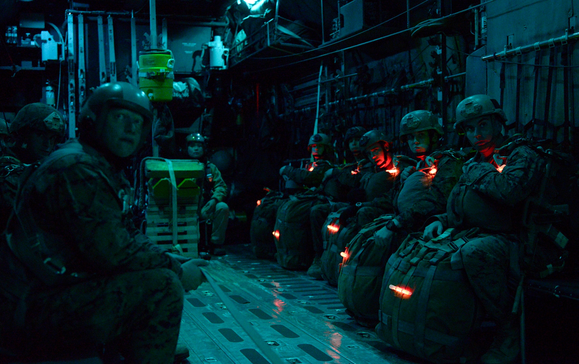Marines with freshly-lit glow sticks wait for jump orders on a C-130 Hercules over Yokota Air Base, Japan, Nov. 21, 2013. The Marines travel around the Pacific region to conduct their required minimum of four jumps a year, jumping at Yokota this time. (U.S. Air Force photo by Senior Airman Cody H. Ramirez)