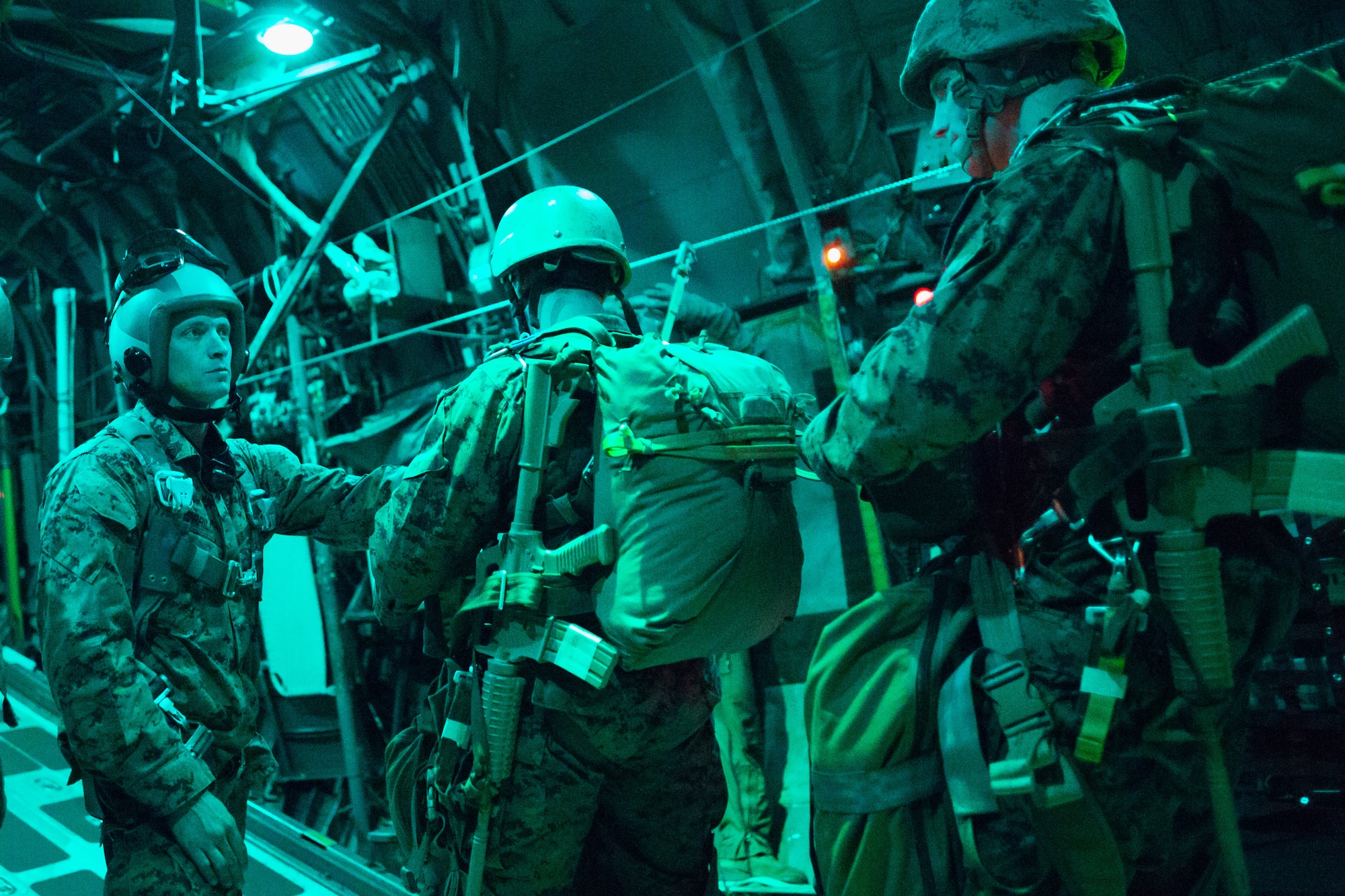 Marines with the 3rd Reconnaissance Battalion, 3rd Marine Division, III Marine Expeditionary Force, prepare to jump out of a C-130 Hercules over Yokota Air Base, Japan, Nov. 21, 2013. The training not only allowed the marines to practice jumping, but it also allowed the Yokota aircrews to practice flight tactics and timed-package drops. (U.S. Air Force photo by Osakabe Yasuo/Released)