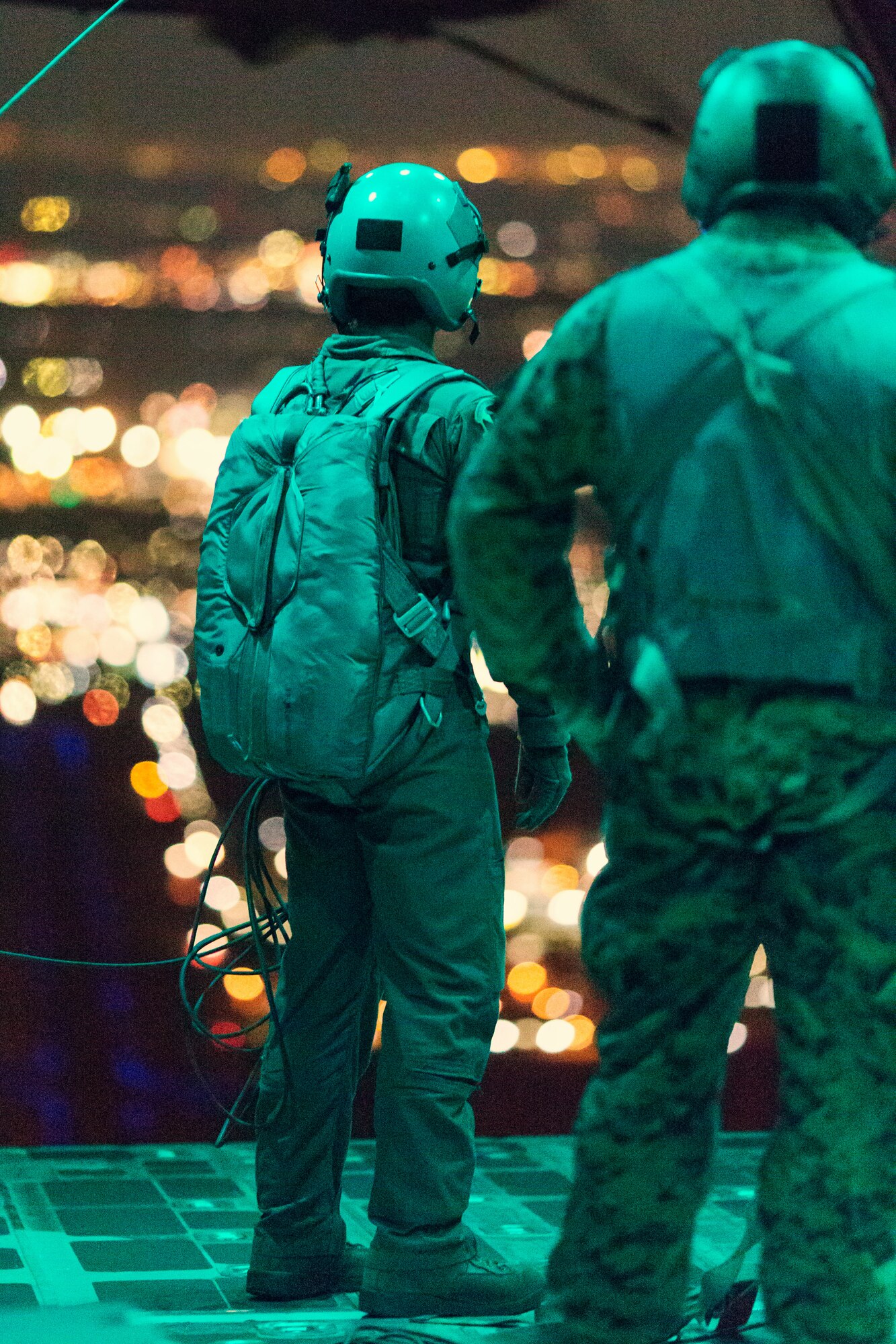 A Marine with the 3rd Reconnaissance Battalion, 3rd Marine Division, III Marine Expeditionary Force and an Airman from the 36th Airlift Squadron, observe Marine paratroopers after jumping from a C-130 Hercules over Yokota Air Base, Japan, Nov. 21, 2013. The training not only allowed the marines to practice jumping, but it also allowed the Yokota aircrews to practice flight tactics and timed-package drops. (U.S. Air Force photo by Osakabe Yasuo/Released)