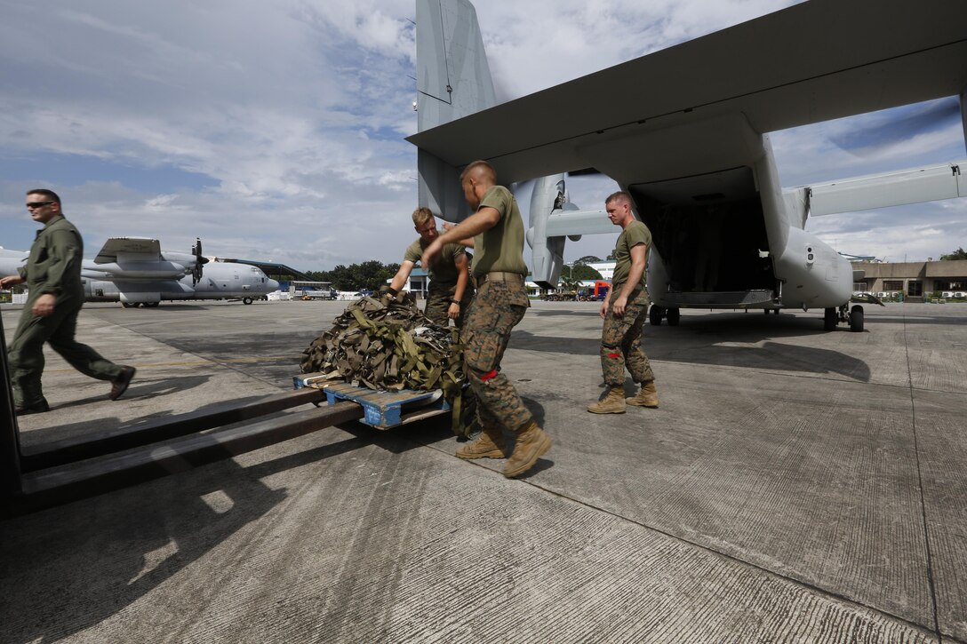 U.S. Marines with Combat Logistics Battalion 4, currently assigned to 3D Marine Expeditionary Brigade (3D MEB), in support of Joint Task Force 505 (JTF-505), gather supplies off an MV-22B Osprey with Marine Medium Tiltrotor Squadron 262 (VMM-262), on Villamor Air Base, Philippines, Nov. 21, 2013.  The Marines with VMM-262 conduct humanitarian evacuations in support of Operation Damayan.  (U.S. Marine Corps photo by Lance Cpl. Luis A. Rodriguez III/ Not Released)