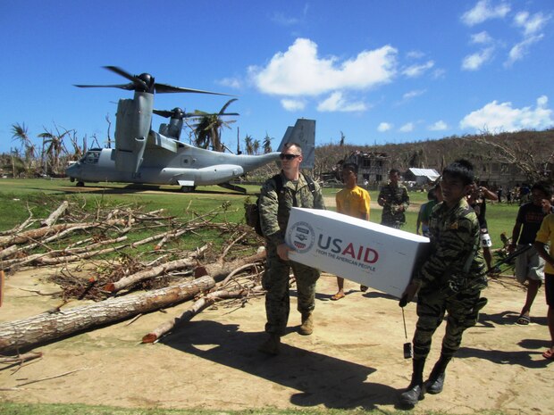 U.S. Marine Capt. Joseph White, left, of Barstow, Calif., the deputy logistics officer of the 31st Marine Expeditionary Unit and Philippine Army PFC Vic D. Victorlano carry U.S. Agency for International Development relief supplies from an MV-22 Osprey tiltrotor aircraft, Nov. 18. A bilateral assessment team landed to deliver relief and determine needs in remote areas in and near Leyte to assess the needs of people isolated by Typhoon Haiyan. U.S. military assets have delivered relief supplies provided by the U.S. Agency for International Development since the start of Operation Damayan, in support of the Government of the Philippines in the wake of Typhoon Haiyan.