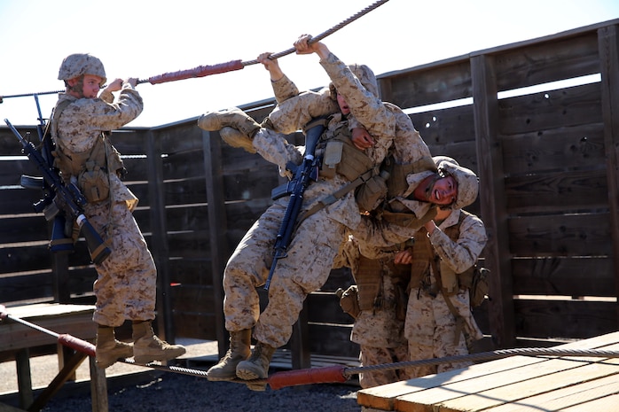 A fire team of Company I recruits, 3rd Recruit Training Battalion, work to transport a simulated casulity across a rope bridge while solving one of the obstacles presented by the 12 Stall; that recruits couldn't touch anything painted red. 