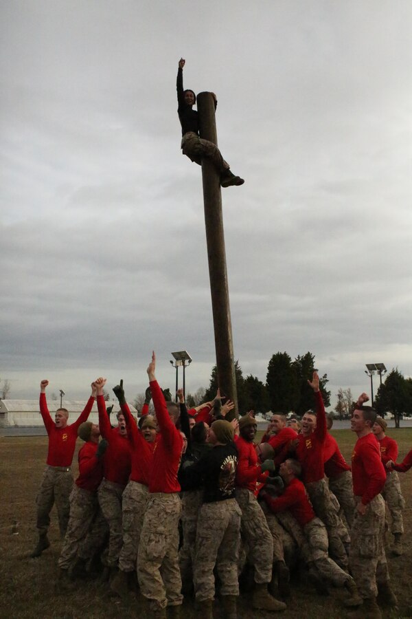Marine candidates raise a log with a fellow candidate atop it during a field meet at Officer Candidates School on Nov. 21, 2013. The field meet is one of the final events candidates participate in before graduation.