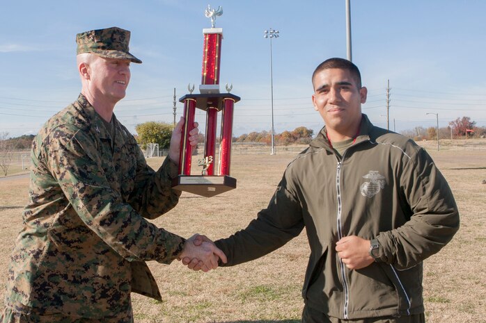NORFOLK, Va. (Nov. 22, 2013) - Pfc. William Zuniga, an administrative clerk with Headquarters and Service Battalion, U.S. Marine Corps Forces Command, accepts a trophy from Col. Paul Ryan, commanding officer, HQSVBN, Nov. 22. Marine Corps Community Services, Camp Allen hosted the annual Hampton Roads Regional Field Meet at Captain Slade Cutter Athletic Park. Marines from units all over Hampton Roads were invited to attend and compete. This year, Fleet Anti-Terrorism Security Team (FAST), Company C, took first place, followed by Headquarters and Service Battalion, U.S. Marine Corps Forces Command and I&I Staff Hampton Roads. Throughout the day, the Marines participated in various competitions and ate barbecue.