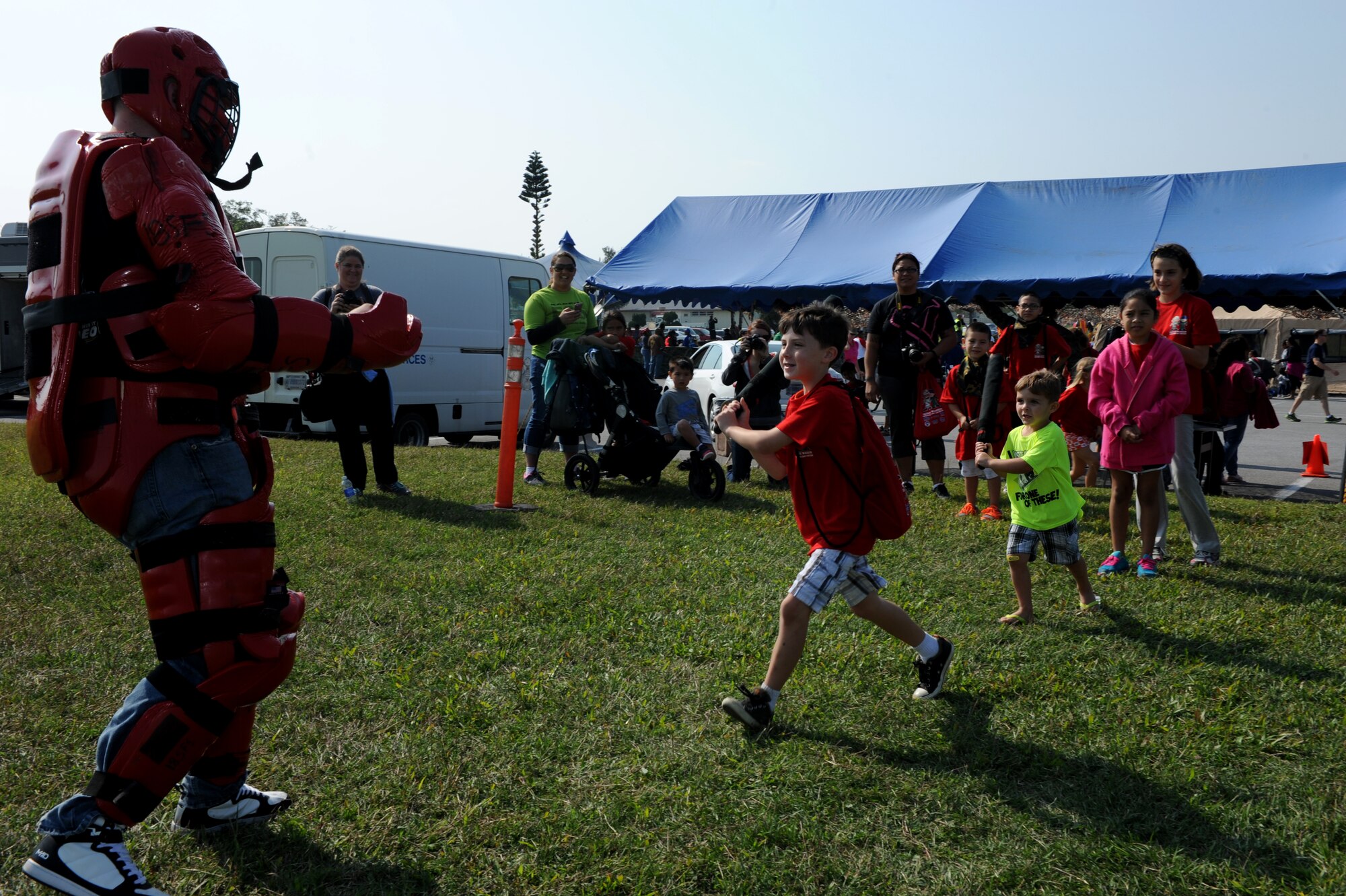 Skoshi Warrior participants learn how to take down a perpetrator who refuses to cooperate with law enforcement during the event on Kadena Air Base, Japan, Nov. 23, 2013. More than 200 children across the island participated in Skoshi Warrior, learning about various units like security forces, the explosive ordnance disposal flight, the fire department and much more. Participants also ran through an obstacle course and watched an HH-60 Pave Hawk helicopter take off to conclude the event. (U.S. Air Force photo by Airman 1st Class Hailey R. Davis)