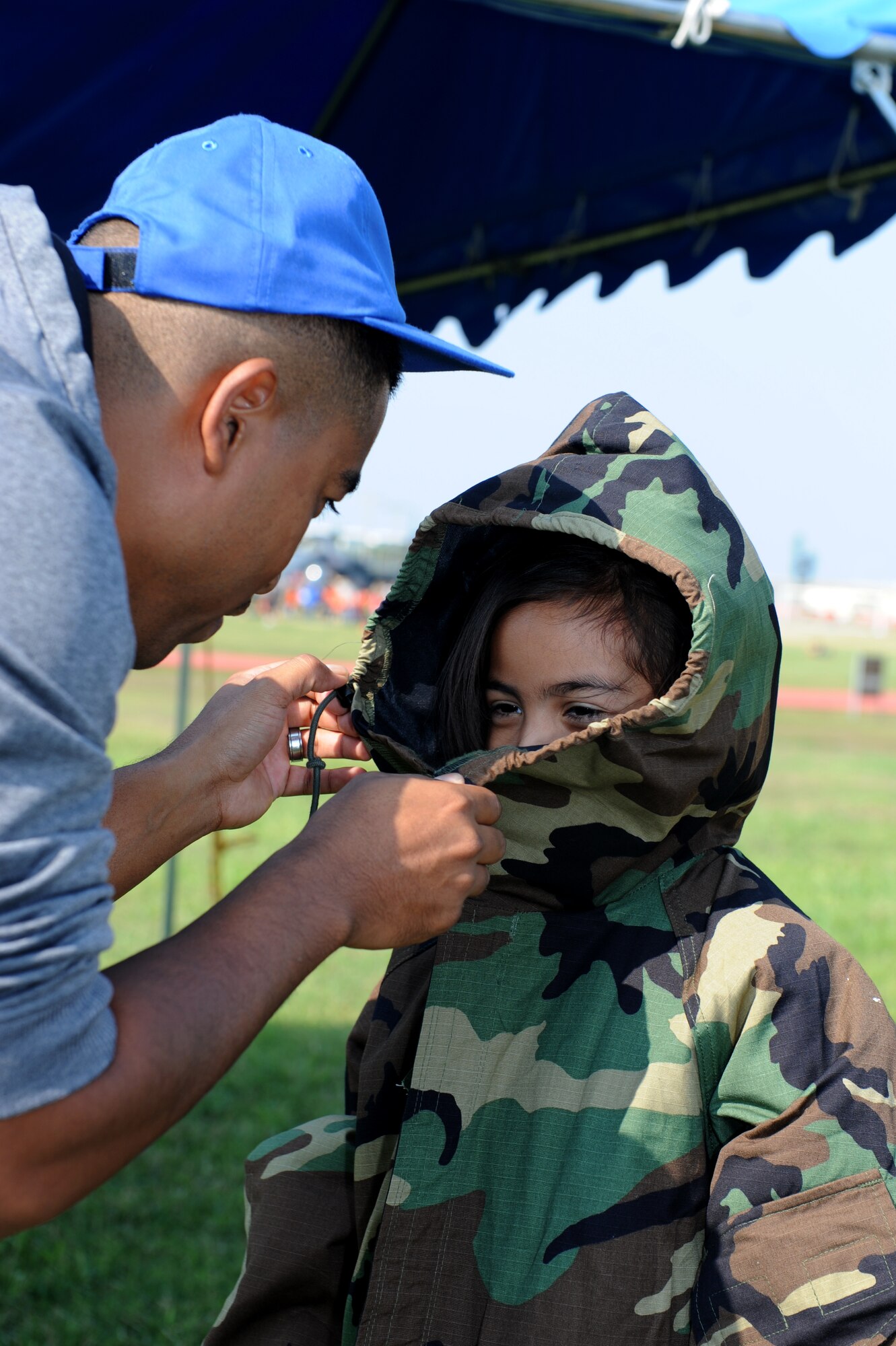 A Skoshi Warrior participant learns how to properly wear individual protective equipment during Skoshi Warrior on Kadena Air Base, Japan, Nov. 23, 2013. Skoshi Warrior is an annual event that provides children with a fun, yet realistic depiction of the deployment process their parents go through when they are tasked to deploy. (U.S. Air Force photo by Airman 1st Class Hailey R. Davis)