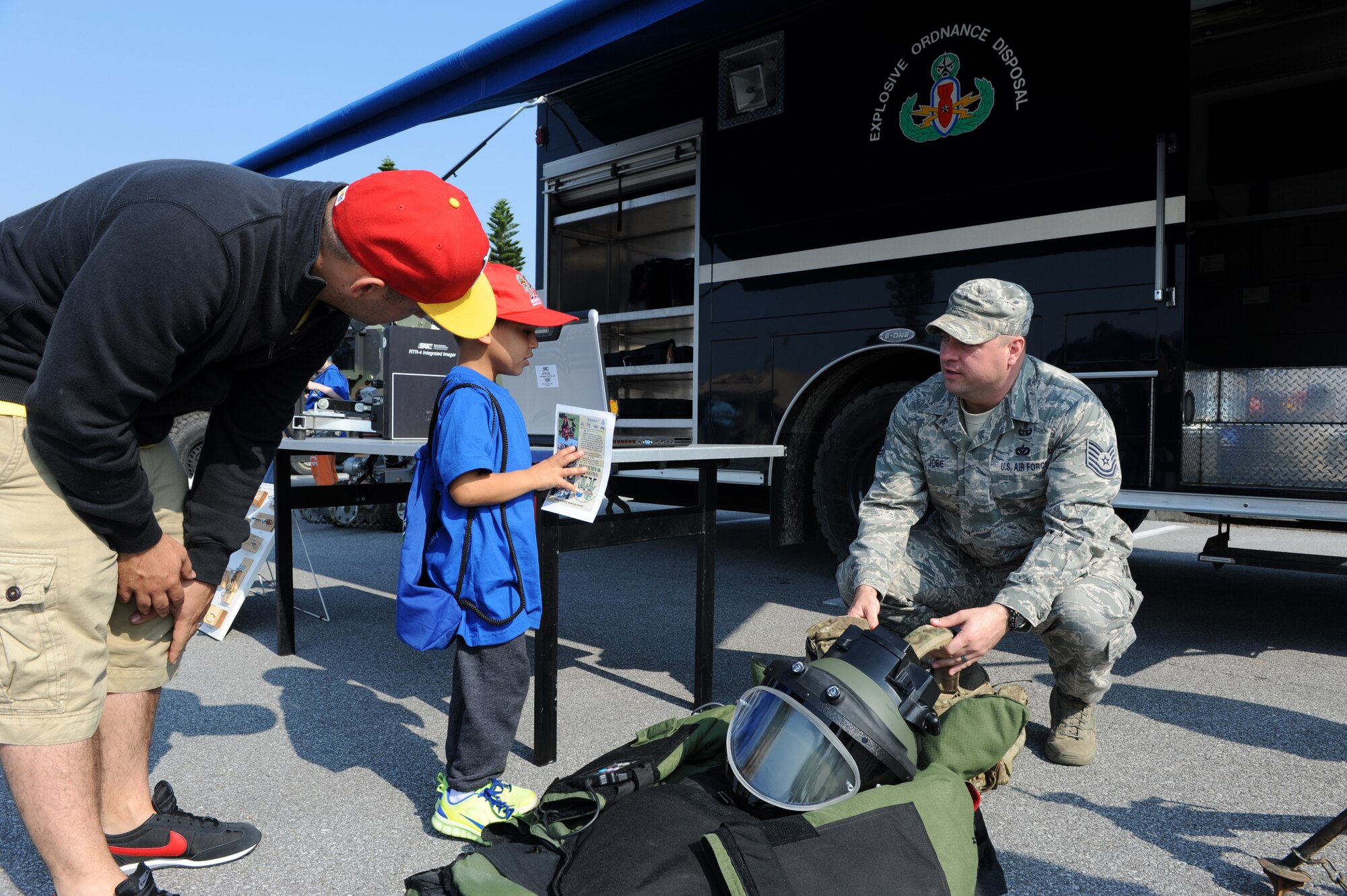U.S. Air Force Tech. Sgt. Micah Jobe, 18th Explosive Ordnance Disposal technician, explains a bomb disposal suit to a Skoshi Warrior participant on Kadena Air Base, Japan, Nov. 23, 2013. During the event, participants viewed various explosive ordnance, the bomb disposal suit and an F-6 explosive ordnance disposal robot, which is used when responding to EOD calls. (U.S. Air Force photo by Airman 1st Class Hailey R. Davis)