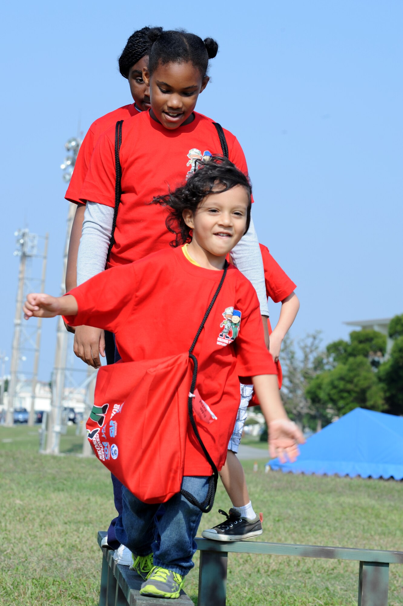Skoshi Warrior participants balance on a beam while running through an obstacle course at Kadena's Skoshi Warrior event on Kadena Air Base, Japan, Nov. 23, 2013. Children crawled through tunnels, balanced on beams and threw water balloons at a target during the obstacle course. (U.S. Air Force photo by Airman 1st Class Hailey R. Davis)