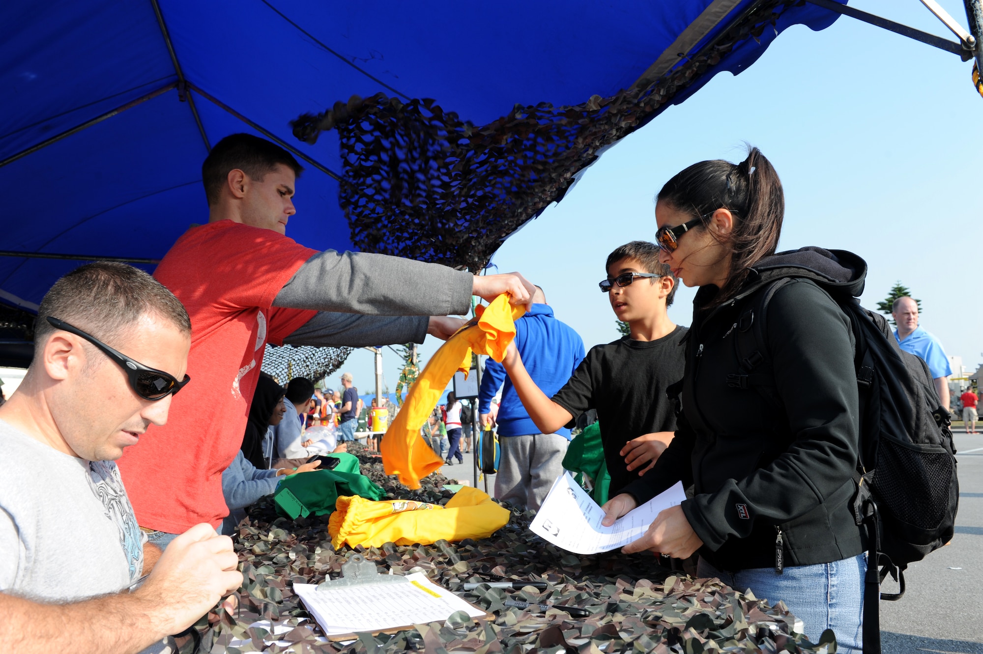 Skoshi Warrior volunteers sign in participants prior to the event on Kadena Air Base, Japan, Nov. 23, 2013. Skoshi Warrior is an annual event for children of military members highlighting aspects of a military member's deployment process in a fun and safe environment. Participants ran through an obstacle course, saw a military working dog demonstration, received information from security forces and fire department personnel and watched an HH-60 Pave Hawk helicopter take off to conclude the event. (U.S. Air Force photo by Airman 1st Class Hailey R. Davis) 
