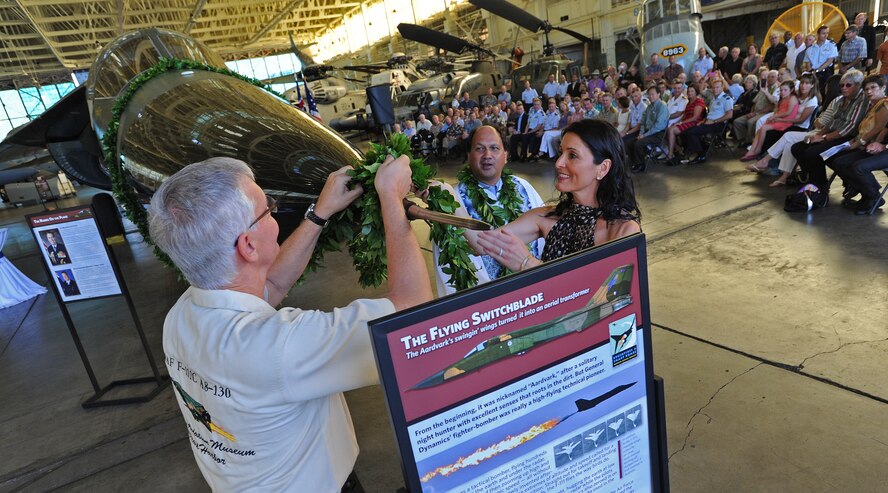 Museum Executive Director Kenneth DeHoff, left, and his spouse Tanja DeHoffuntie tie leaves as Kahu Kordell Kekoa, center explains the Hawaiian traditional blessing using ti leaves and Hawaiian water during the Royal Australian Air Force F-111C dedication ceremony in honor of Royal Australian Air Force Air Marshal Geoffrey Brown at the Pacific Aviation Museum, Ford Island, Hawaii, Nov. 23, 2013.   Theater Security Cooperation, one of five Pacific Air Forces lines of operation, focus on enabling PACAF forces and other nations' Air Force forces to exchange ideas, techniques, and procedures on missions that Pacific partners see as vital to achieving success during both steady-state and/or contingency operations. This Line of Operation is key to enabling all operations within the area of responsibility.  (U.S. Air Force photo/Tech Sgt. Jerome S. Tayborn/Released)