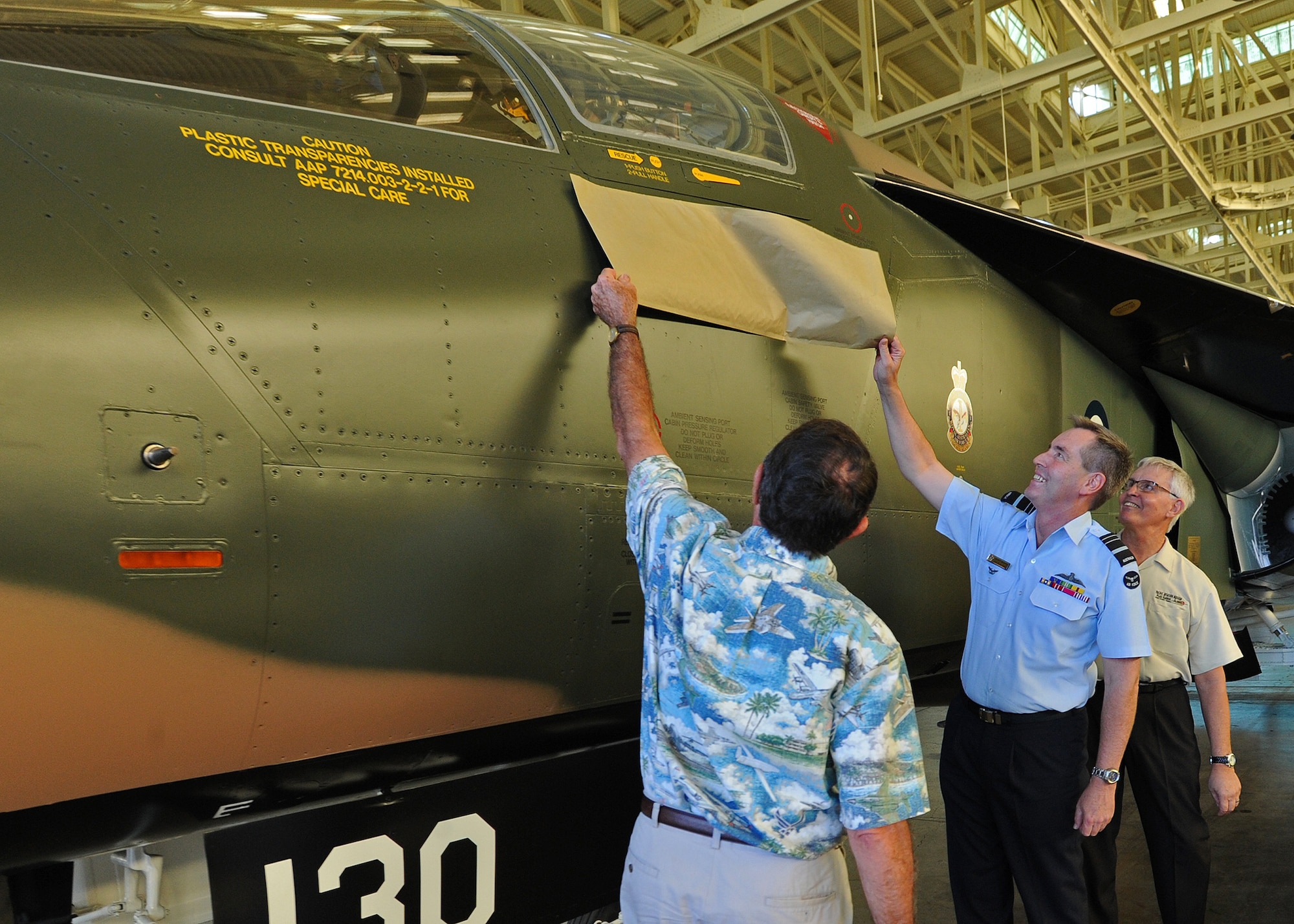 From left, Museum Board President Clint Churchill, Air Marshal Geoffrey Brown, Royal Australian Air Force Chief of Air Force and Museum Executive Director Kenneth DeHoff unveil an RAAF F-111C at Pacific Aviation Museum, Ford Island, Hawaii, Nov. 23, 2013. The aircraft was marked with Brown’s name, the plane’s former pilot who played a key role in the development and modernization of the F-111 fleet for the RAAF.  Both the U.S. and Australia continue to look for areas where it would be mutually beneficial to deepen their longstanding alliance in order to minimize strategic gaps in the Asia-Pacific region, improve air force-to-air force interoperability, and share responsibility for leading robust multi-lateral operations. (U.S. Air Force photo/Tech Sgt. Jerome S. Tayborn/Released)