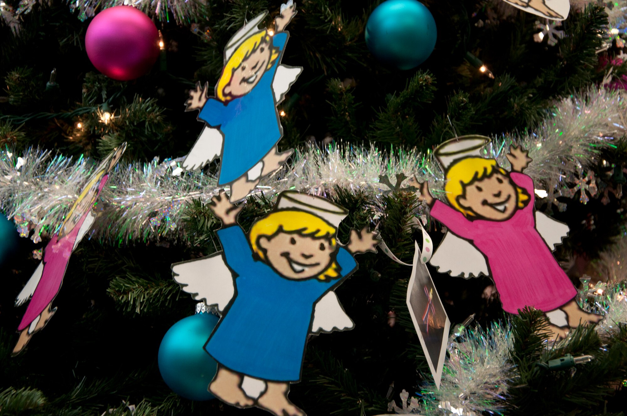 “Angel ornaments” hang on the angel tree in the F.E. Warren Base Exchange Nov. 25, 2013. Warren’s First Sergeant’s Council sponsors the Angel Tree Program, which provides assistance to local families in need during the holidays. The Angel Tree, located in the Exchange, contains the wishes of 112 children, 30 of them from deployed families. On each “angel ornament,” an information card contains a child’s age, gender, clothing sizes and special gift requests. Donating individuals may choose one or more angels and purchase unwrapped gifts with the angel attached to them. The gifts are then left in the box next to the Angel Tree and will be delivered to the identified families at the end of the campaign, Dec. 9, 2013. (U.S. Air Force photo by Tech. Sgt. Stacy Foster)