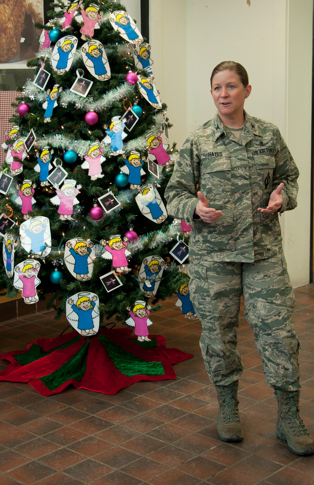 Col. Tracey Hayes, 90th Missile Wing commander, discusses the Angel Tree Program during the kick-off ceremony in the F.E. Warren Base Exchange Nov. 25, 2013. Warren’s First Sergeant’s Council sponsors the program which provides assistance to local families in need during the holidays. The Angel Tree, located in the Exchange, contains the wishes of 112 children, 30 of them from deployed families. On each “angel ornament,” an information card contains a child’s age, gender, clothing sizes and special gift requests. Donating individuals may choose one or more angels and purchase unwrapped gifts with the angel attached to them. The gifts are then left in the box next to the Angel Tree and will be delivered to the identified families at the end of the campaign, Dec. 9, 2013. (U.S. Air Force photo by Tech. Sgt. Stacy Foster)