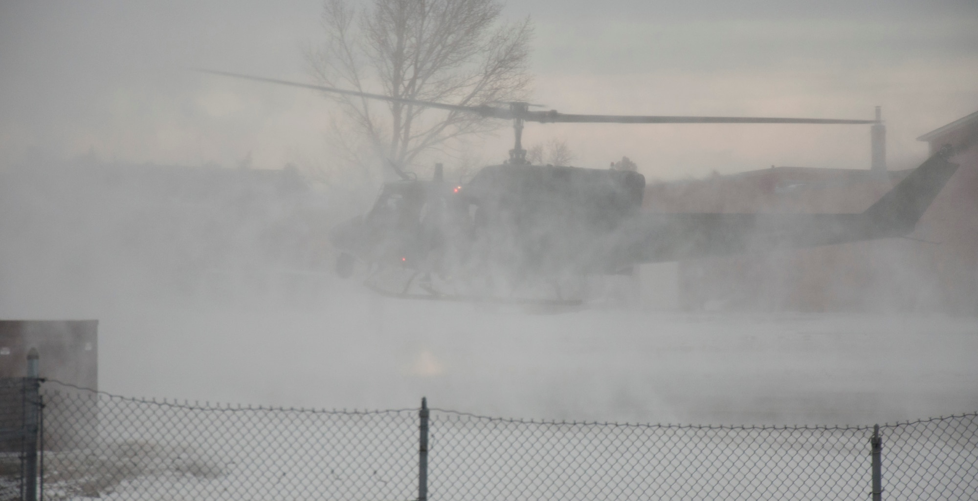 A UH-1N Huey helicopter, filled with defenders from the 790th Missile Security Forces Squadron, lands outside the gates of a training facility during a launch facility recapture demonstration Nov. 22, 2013, during a base tour by Brig. Gen. Allen Jamerson, Director of Security Forces, Deputy Chief of Staff for Logistics, Installations and Mission Support, Headquarters U.S. Air Force, Washington. (U.S. Air Force photo by Airman 1st Class Brandon Valle) 