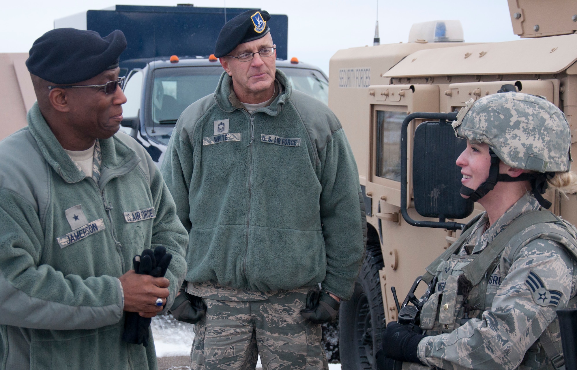 Brig. Gen. Allen Jamerson, Director of Security Forces, Deputy Chief of Staff for Logistics, Installations and Mission Support, Headquarters U.S. Air Force, Washington, D.C., and Chief Master Sgt. Stephen White, Security Forces career field manager, meet with Senior Airman Paige Watson, 90th Missile Security Forces Squadron, during a security forces and TRF demonstration Nov. 22, 2013, at a training facility. Jamerson coined Watson for achieving the 3rd quarter award for SF Airman of the quarter.(U.S. Air Force photo by Airman 1st Class Brandon Valle) 