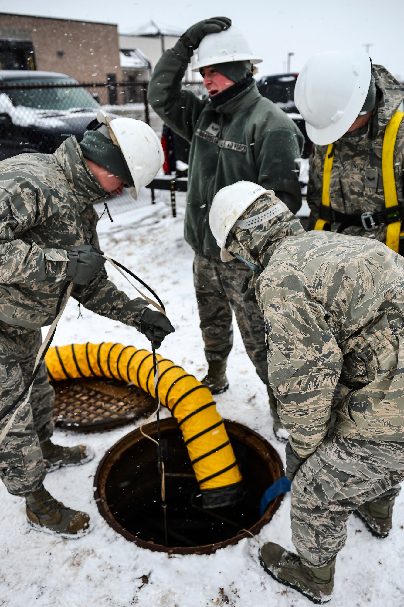 Members of the 460th Space Communications Squadron Cable Antenna Systems Office prepare for confined-spaces training Nov. 21, 2013, near the 460th SCS building on Buckley Air Force Base, Colo. Regardless of the weather, cable antenna systems technicians are required to complete confined-spaces training as part of on-the-job training. (U.S. Air Force photo by Senior Airman Riley Johnson/Released)