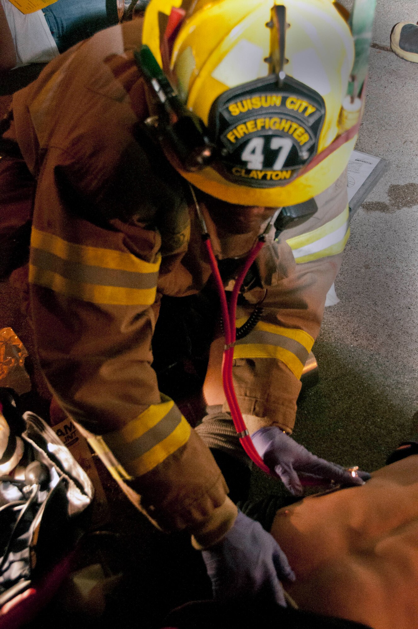 A Suisun fire fighter checks the vitals of a victim suffering from a gunshot to the left leg. Staff Sgt. Nicholas Smith, 60th Civil Engineer Squadron fire fighter, performs as the victim for the exercise at Sierra Vista Elementary School in Vacaville, Calif. Nov. 14. (U.S. Air Force photo/Senior Airman Madelyn Brown)
