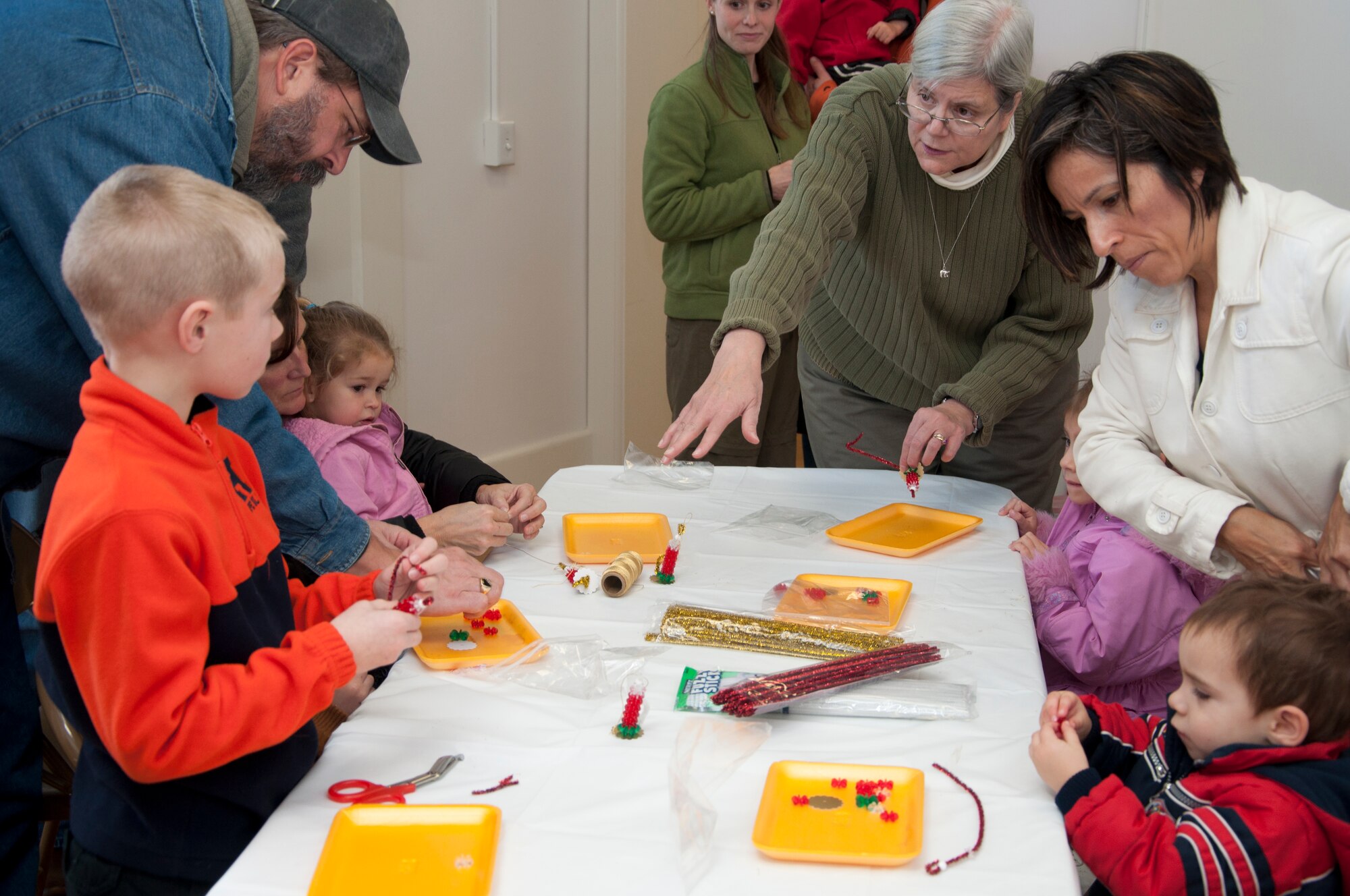 Shawn Bowell, volunteer, instructs children and their parents during an arts and crafts session at the Warren ICBM and Heritage Museum Christmas Open House Nov. 23, 2013. The museum had Victorian Christmas displays and decorations, arts and crafts, period-style candies, photos with Santa and more. (U.S. Air Force photo by Tech. Sgt. Stacy Foster)