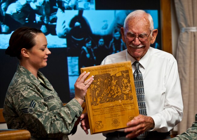 2nd Lt. retired Dean Whitaker, B-17 Flying Fortress pilot and World War II veteran, receives a memento from Airman 1st Class Jade Kristofferson, 6th Combat Training Squadron knowledge operations journeyman, during a WWII Veteran's breakfast Nov. 22, 2013, inside the Club at Nellis Air Force Base, Nev. The memento was presented on behalf of the ACE Council, Operation Warmheart and the Nellis 5-6 group. (U.S. Air Force photo/Senior Airman Brett Clashman)