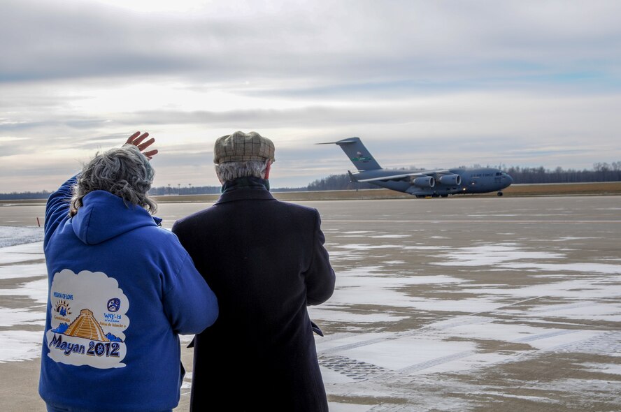 YOUNGSTOWN AIR RESERVE STATION, Ohio—Kathleen Price (left), founder of the Mission of Love Foundation, stands with her husband Robert and waves to a taxiing C-17 aircraft from the 446th Airlift Wing, Joint Base Lewis-McChord, Washington, Nov. 25, 2013. The C-17 arrived here to pick up 14 pallets of humanitarian cargo destined to Guatemala via the Denton Program, which provides military transportation for approved humanitarian assistance commodities destined for approved countries. Mission of Love, a charity based in Austintown, Ohio, collected the cargo. (U.S. Air Force photo/Eric White).