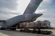 YOUNGSTOWN AIR RESERVE STATION, Ohio—A 76th Arial Port Squadron K-loader pulls up to the ramp of a C-17 aircraft from the 446th Airlift Wing, Joint Base Lewis-McChord, Washington, here, Nov. 25, 2013. The C-17 arrived here to pick up 14 pallets of humanitarian cargo destined to Guatemala via the Denton Program, which provides military transportation for approved humanitarian assistance commodities destined for approved countries. Mission of Love, a charity based in Austintown, Ohio, collected the cargo. (U.S. Air Force photo/Eric White).